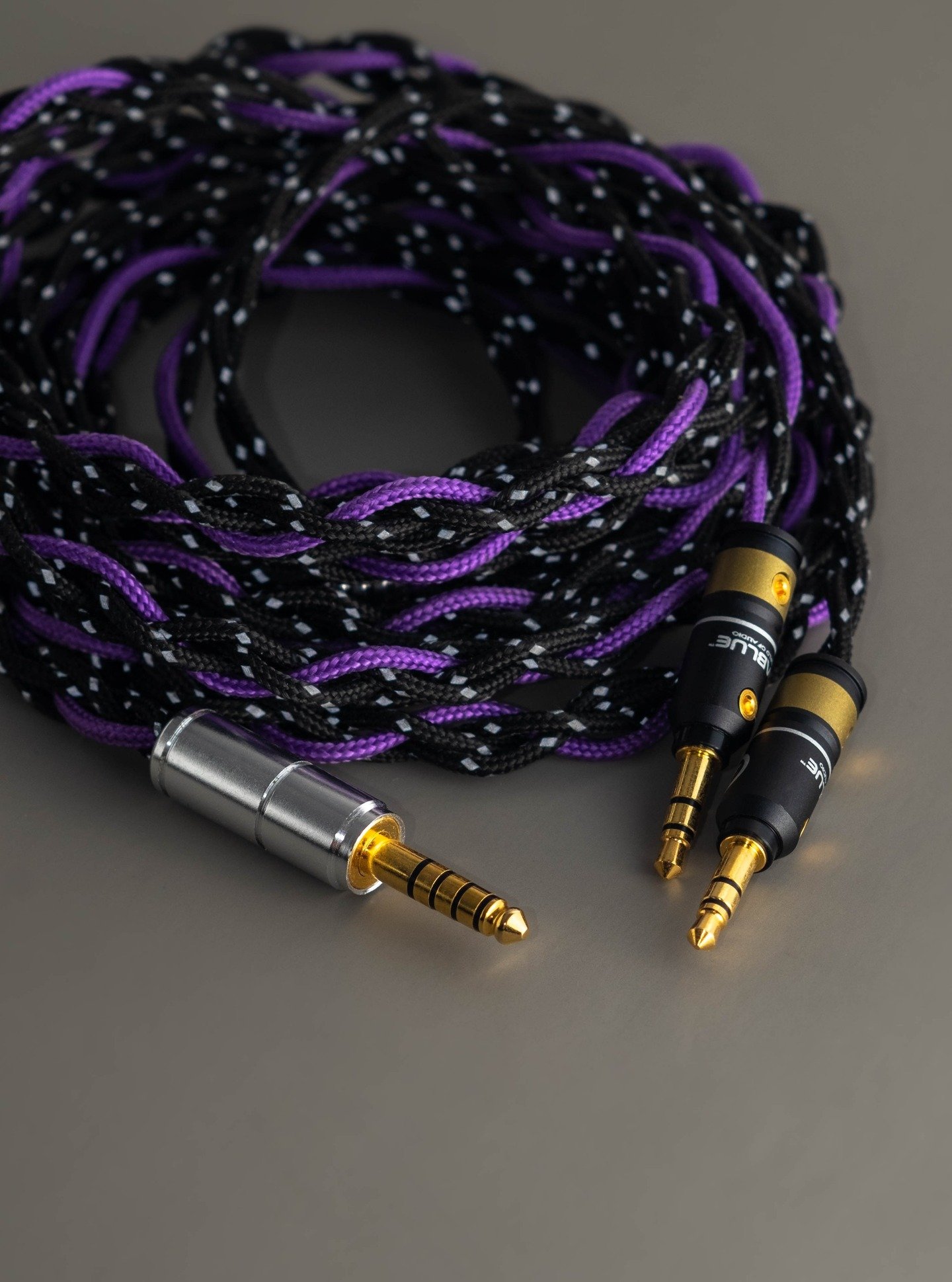 Behold the exquisite Custom SCC Rame II (2nd Generation) cable | a symphony of audio perfection! Braided in striking purple and black with playful white dots, finished with a premium pure copper 4.4mm plug from Gladiator Cables and dual Viablue 3.5mm