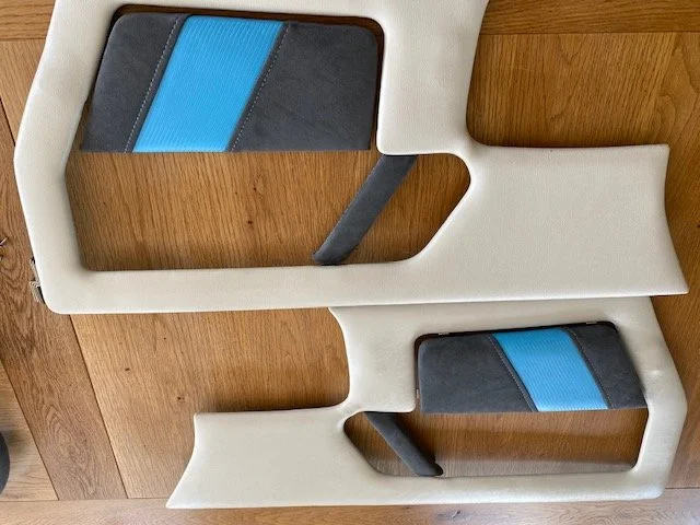 Two chairs with wooden and cushioned parts, viewed from above, arranged back to back.