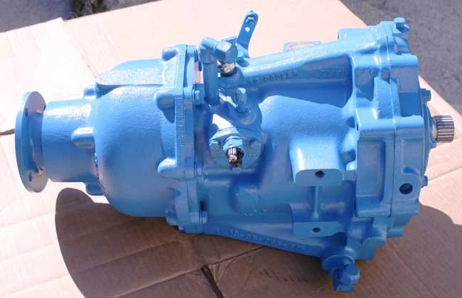 A blue automotive or mechanical gearbox placed on a piece of cardboard.