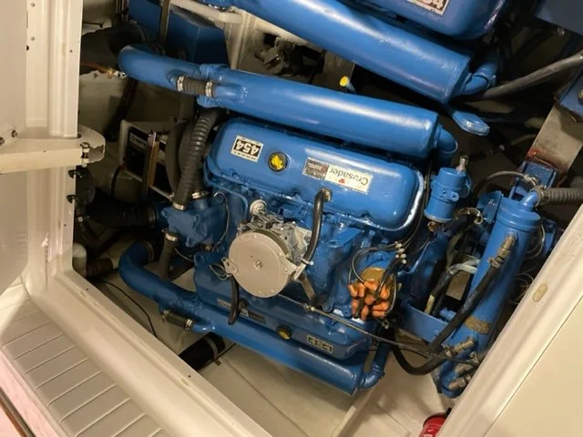 Close-up of a blue marine engine inside a boat engine compartment.
