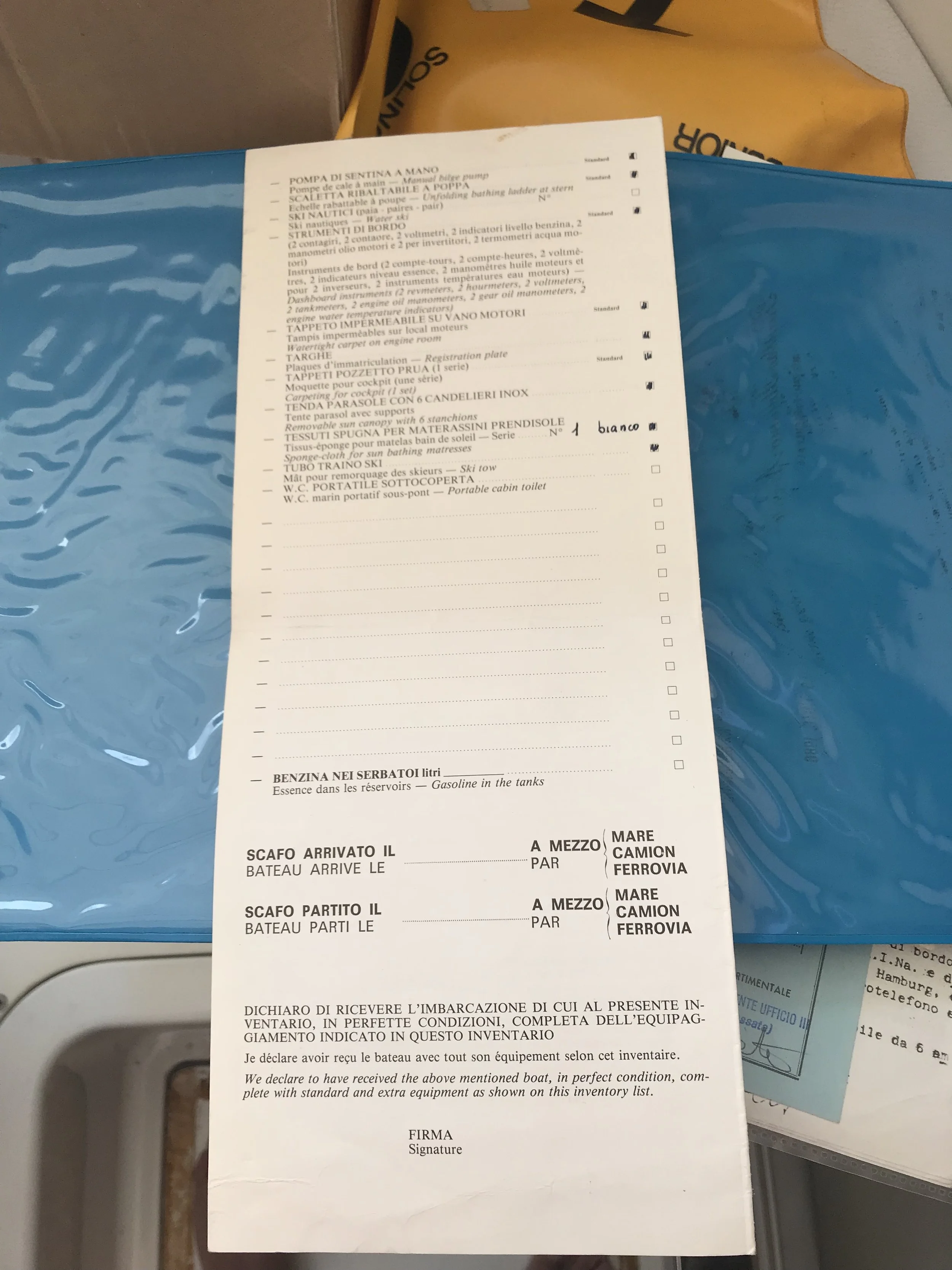 A detailed inventory list with columns and checkboxes, containing items in Italian, French, and English related to boats and camping equipment, including fuel tanks, bathing towels, ski equipment, and portable toilets, with some handwritten notes.