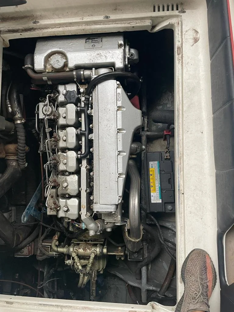 View of a boat engine compartment showing an inline diesel engine and surrounding components.