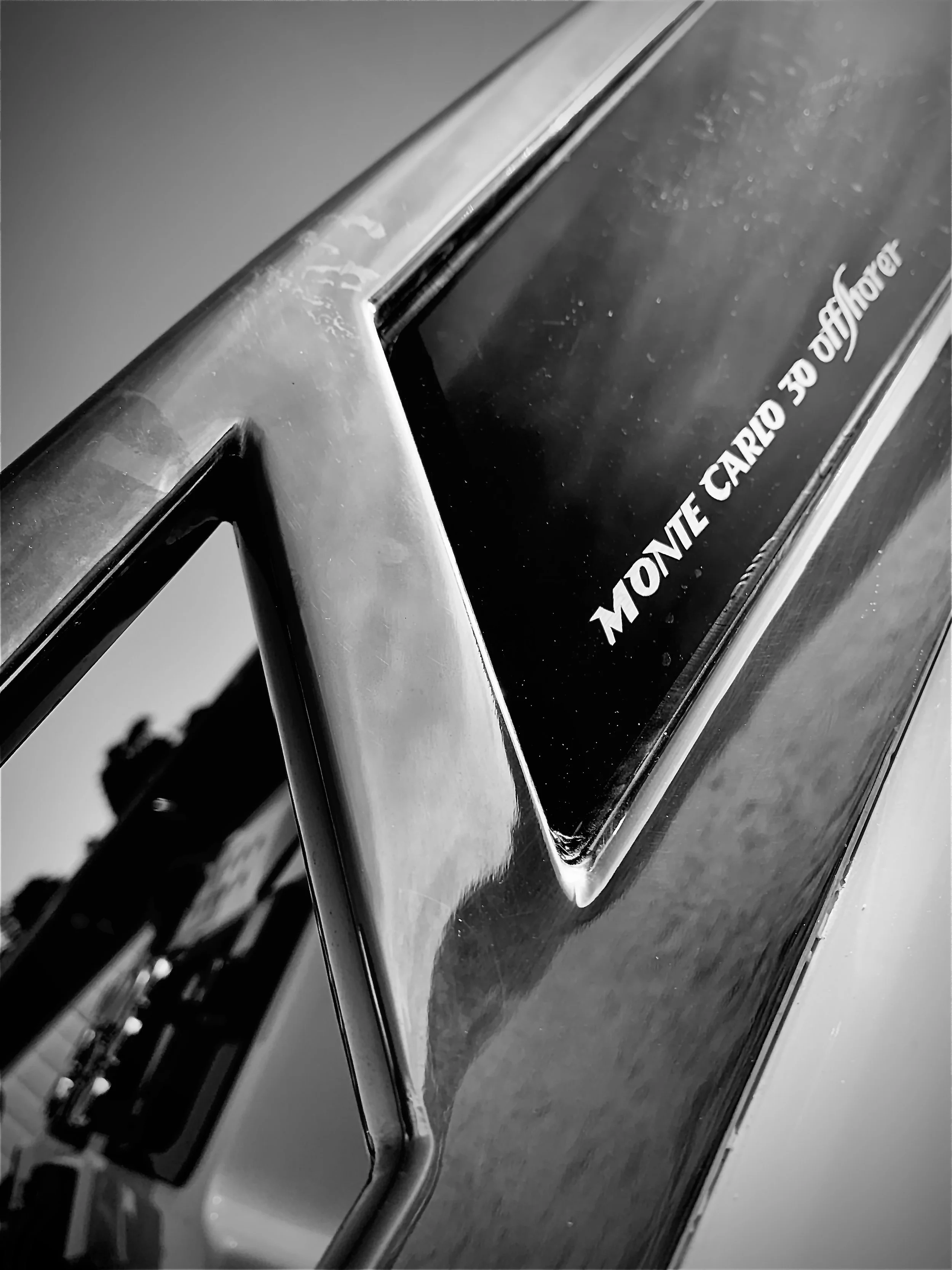 Close-up of a vintage sign reading 'Montone Carlo 30 Offshore' in black and white.