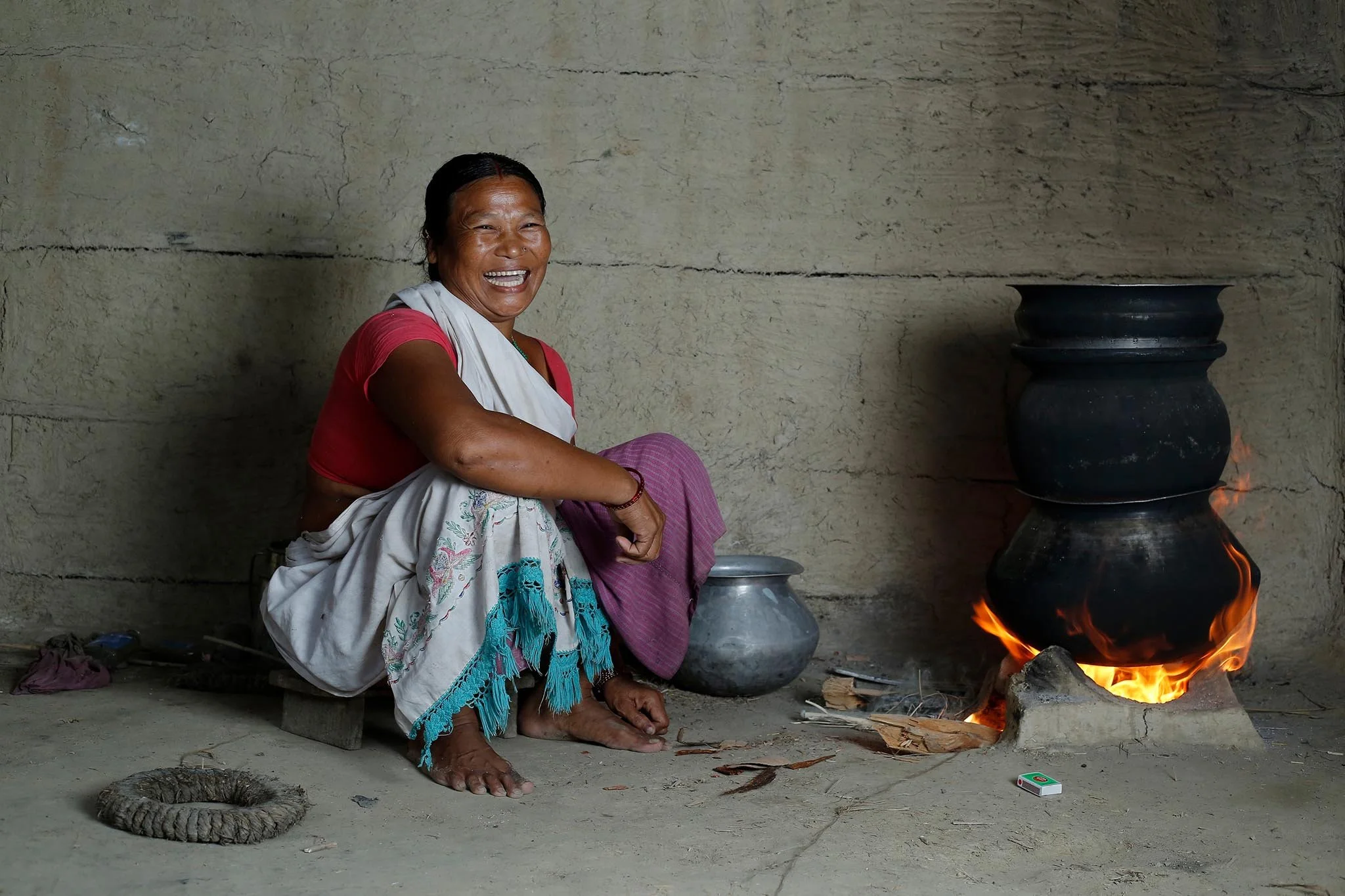 A Tharu woman in her kitchen brewing alcohol. This part of social issue story series is created by photographer Gautam Dhimal for publication.