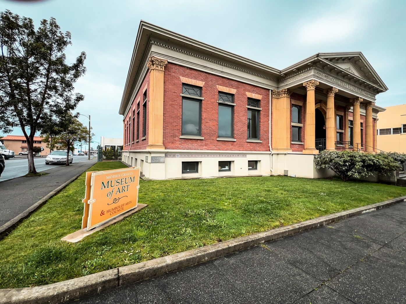 The outside facade of Morris Graves Museum of Art, red brick building with yellow columns