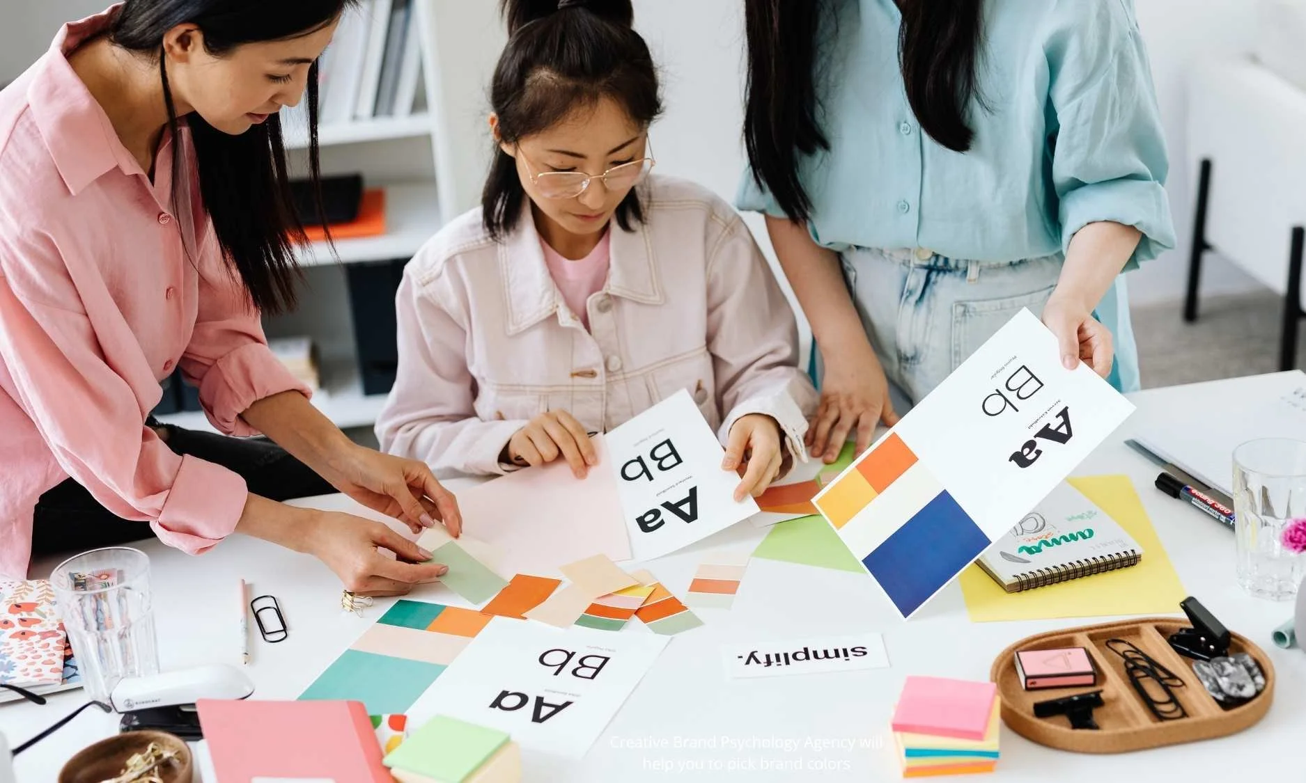 Brand team selecting color palettes and fonts during a brand psychology workshop, aligning brand colors with identity, target audience, and color emotion strategy.