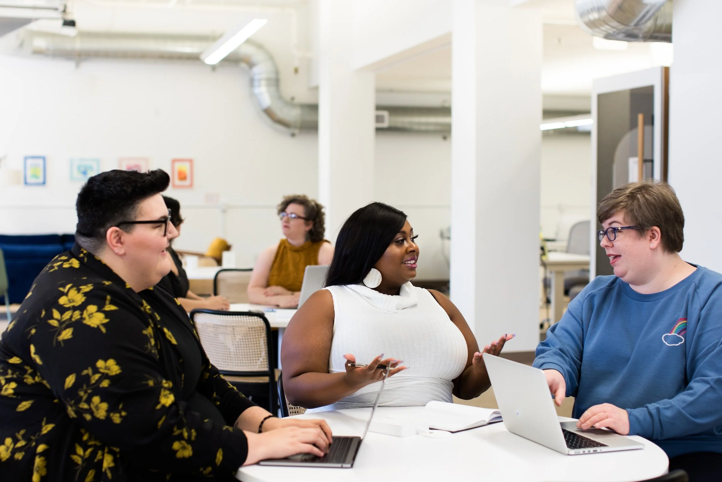 Group of a diverse team having a discussion at a table in a modern office space.