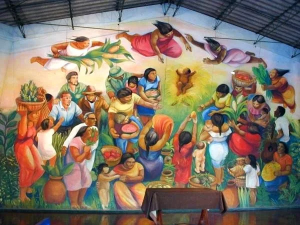A mural with a group of Nicaraguan people surrounding the christ child.