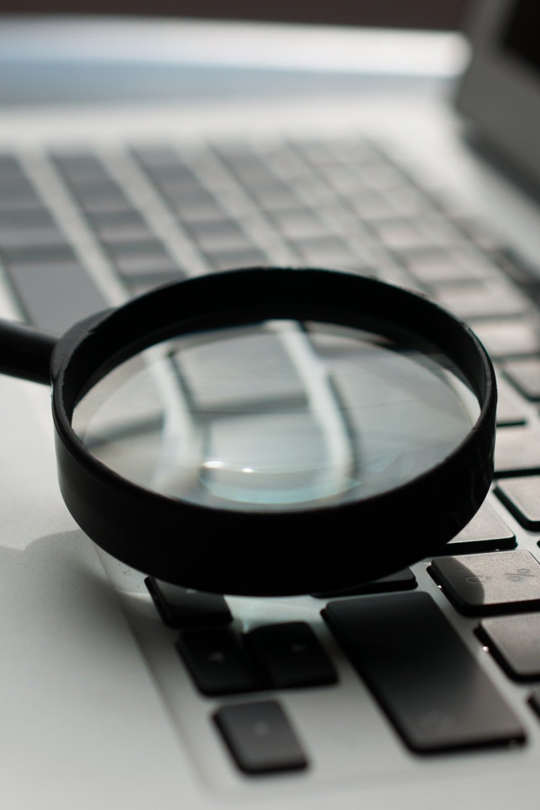 magnifying glass above a laptop keyboard