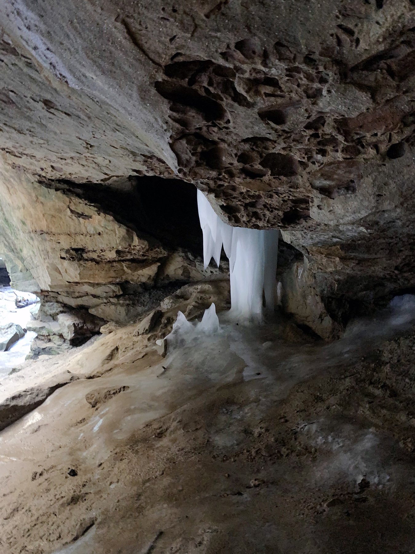 Ice formation, possibly from a seep, alongside two small ice stalagmites.