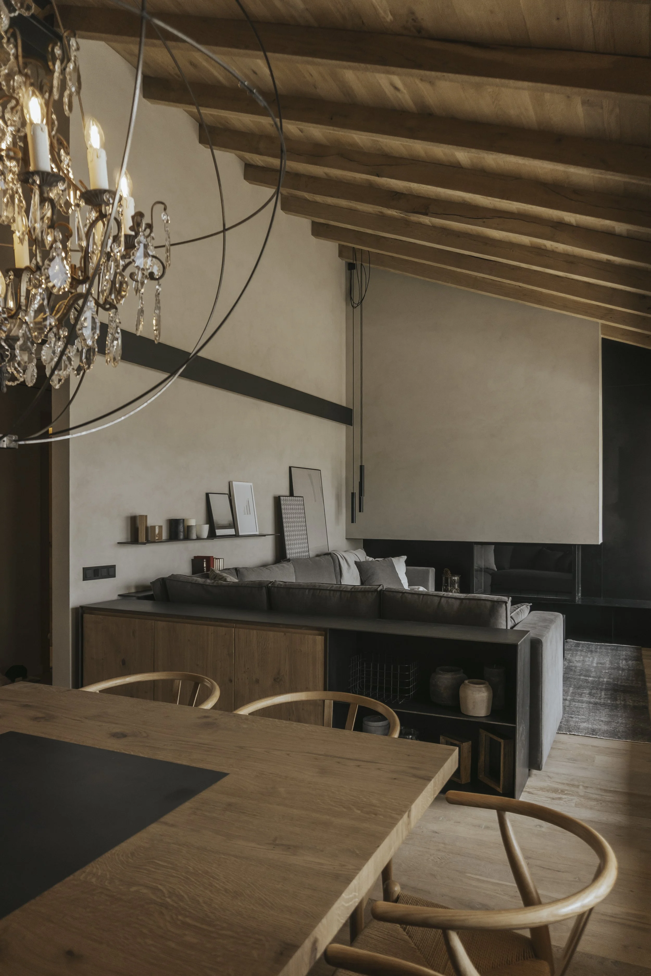Salón con lámpara colgante esférica, aparador con objetos y sillas de comedor
