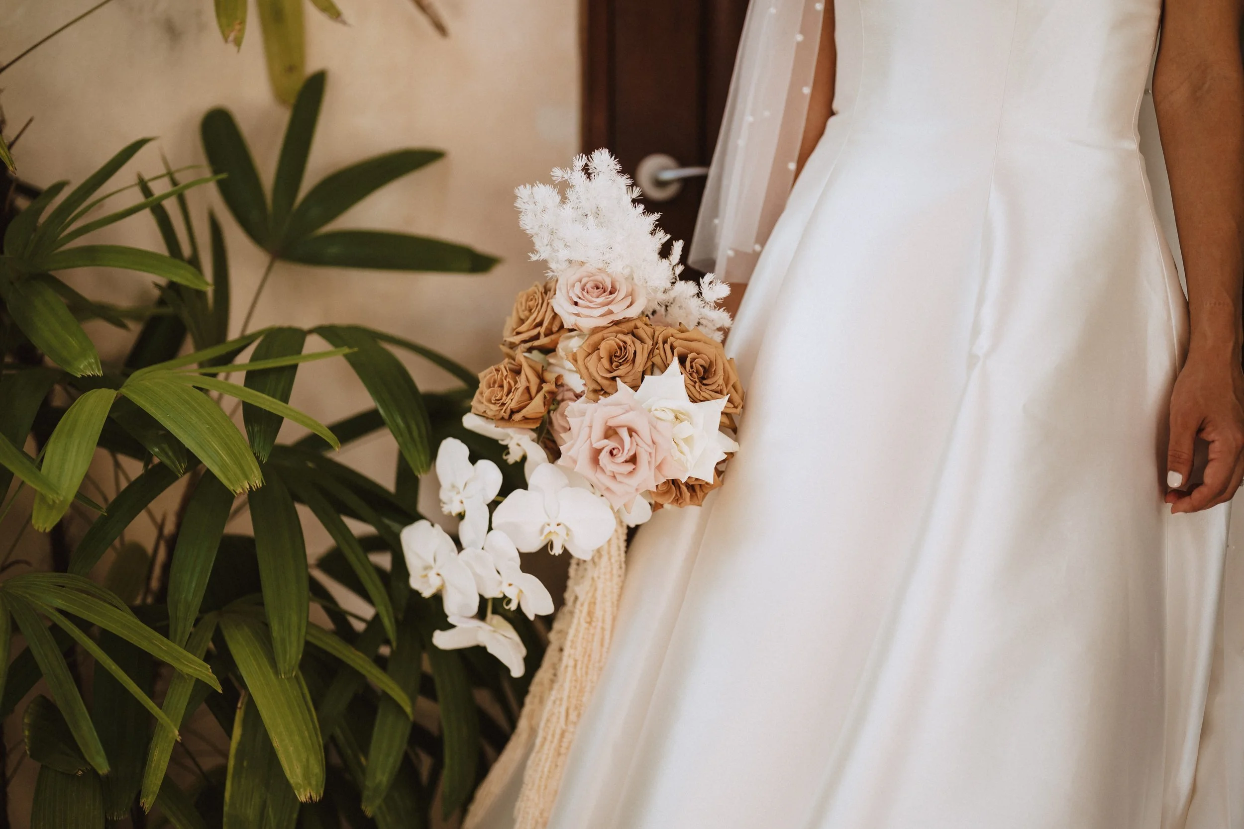 Bride standing with her wedding flowers in her wedding dress before the ceremony.