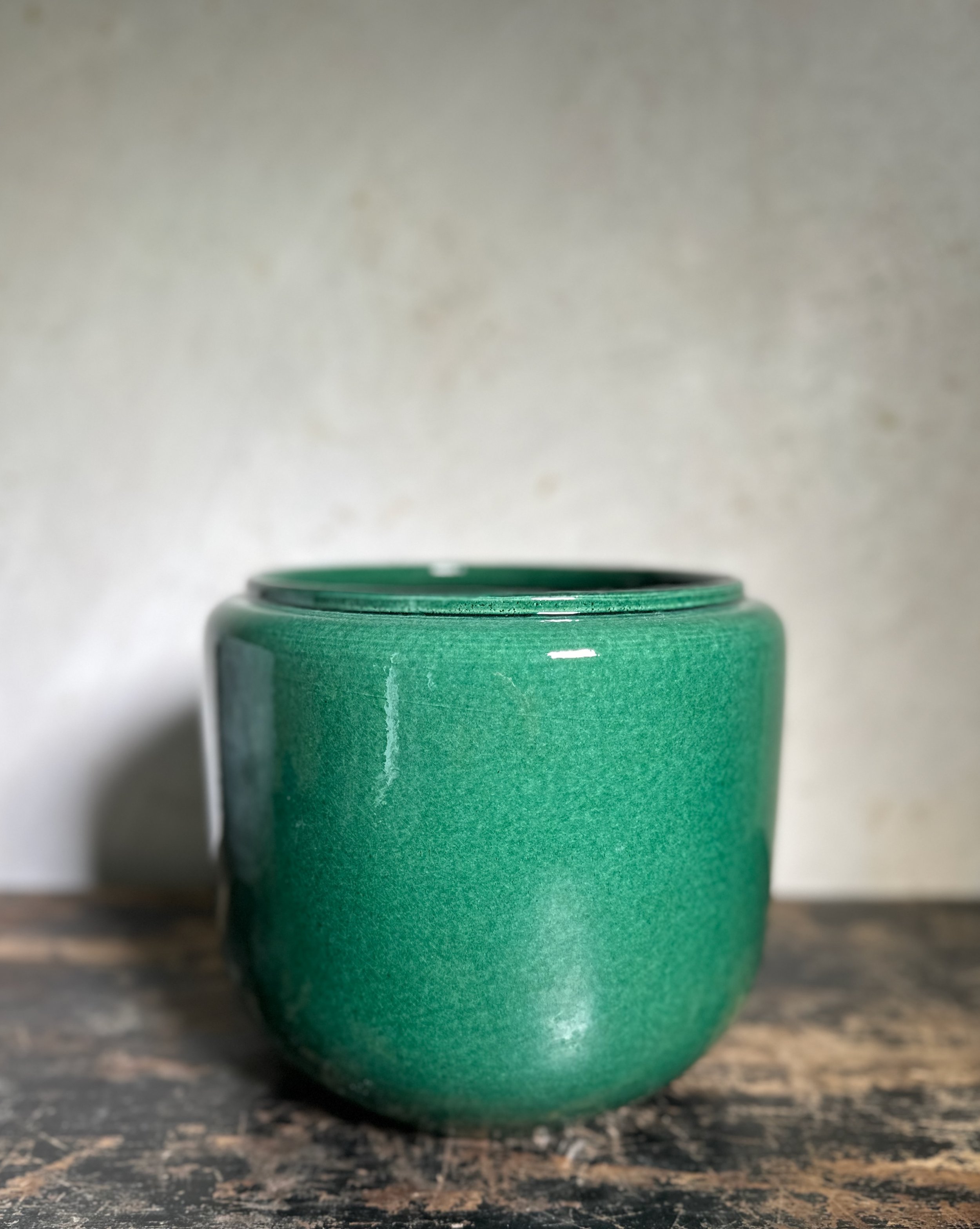 Dark green glazed houseplant pot on table