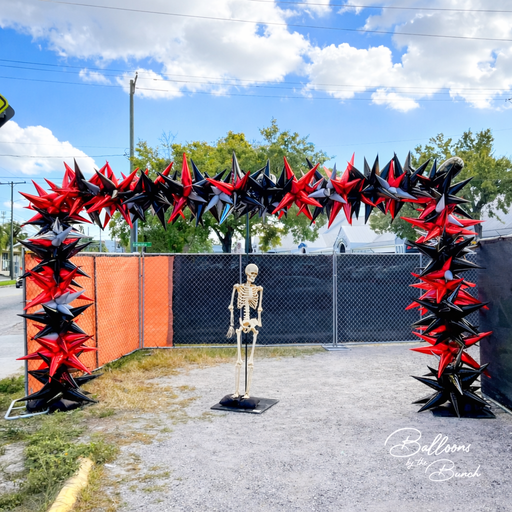 Halloween skeleton under dramatic balloon arch.png