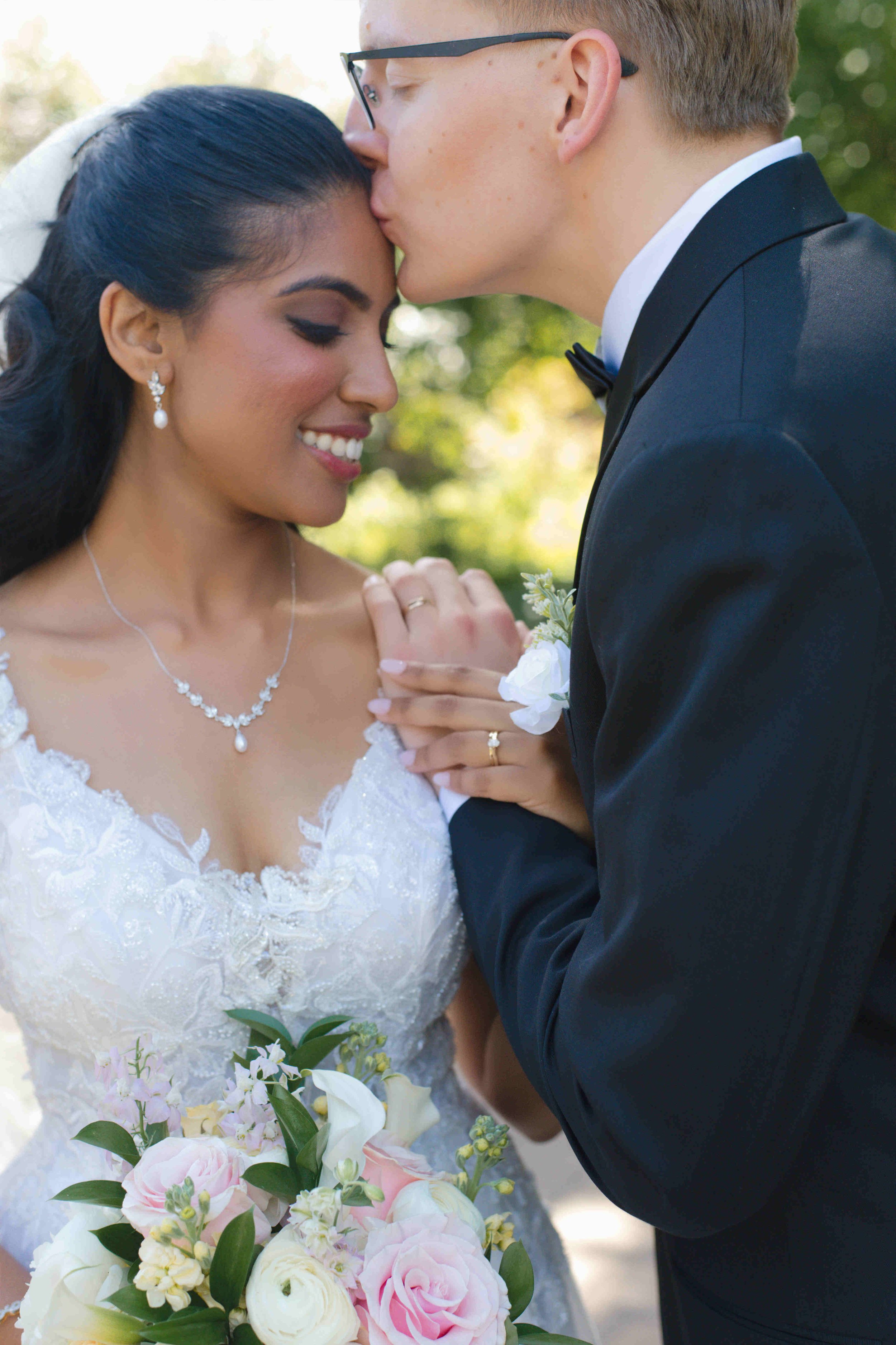 Bride and Groom portrait.  Groom kissing bride on forehead.  Pink and white flower bridal bouquet.  Photo by heather corbin photography.