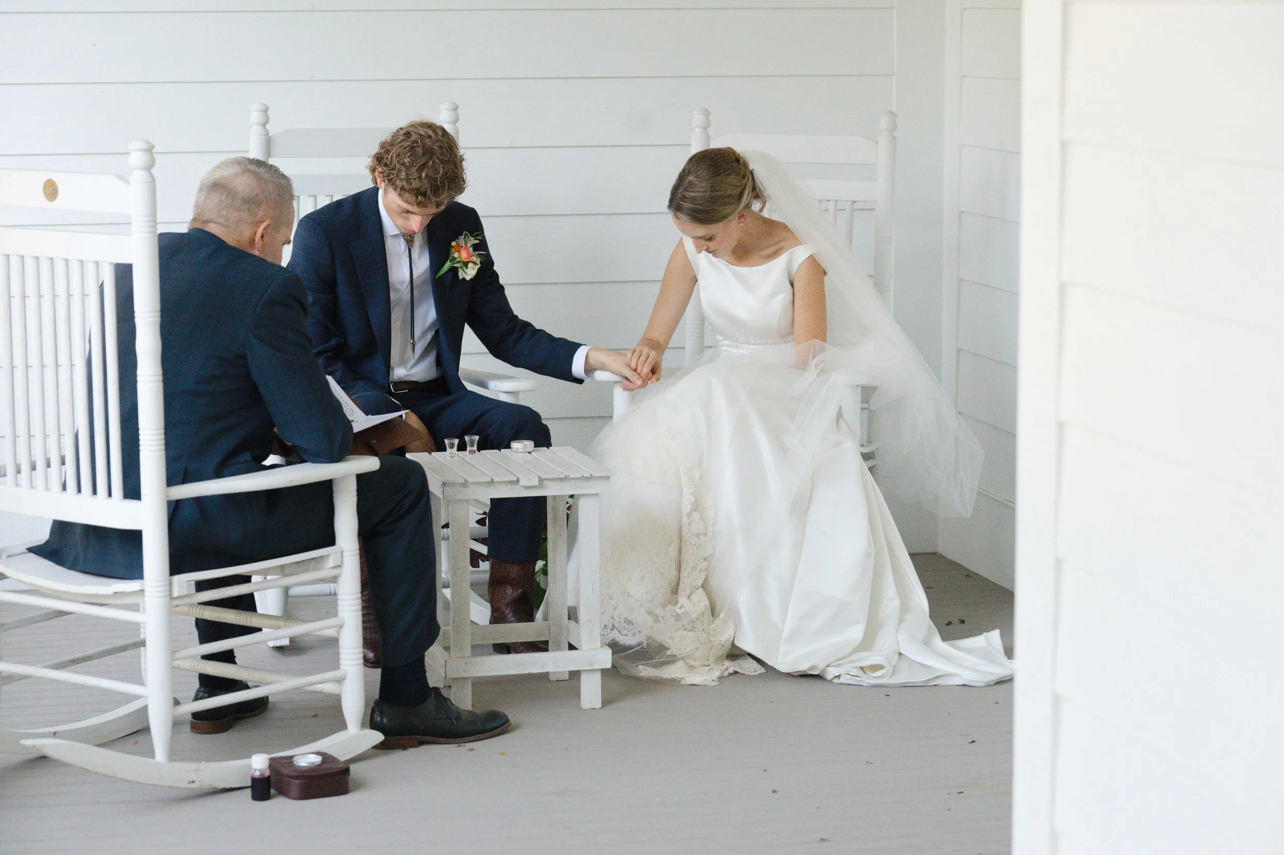 Bride and groom during private first communion as husband and wife on covered front porch while guests were at cocktail hour