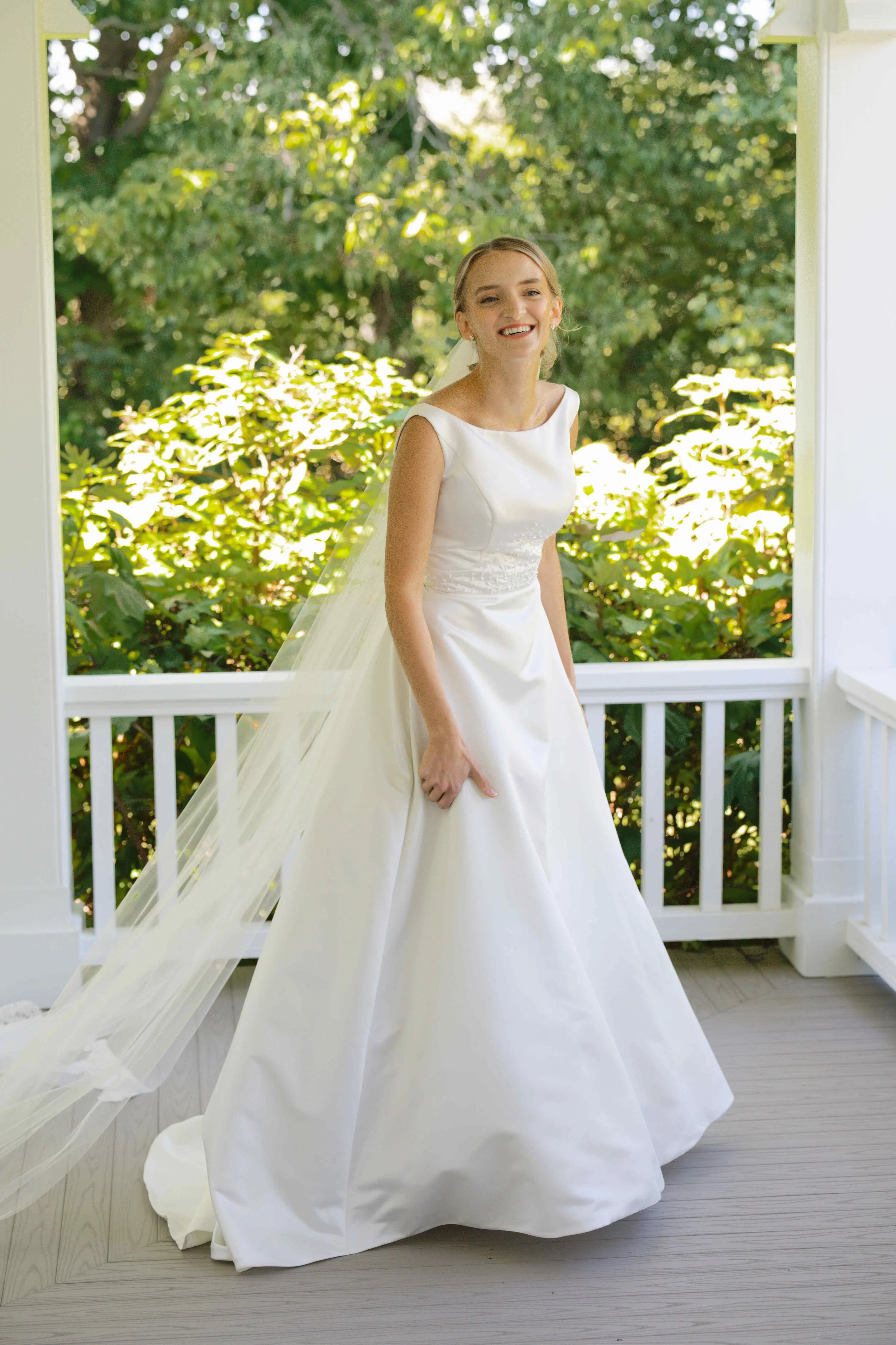 Vintage House of Bianchi wedding dress photographed on farmhouse covered front porch