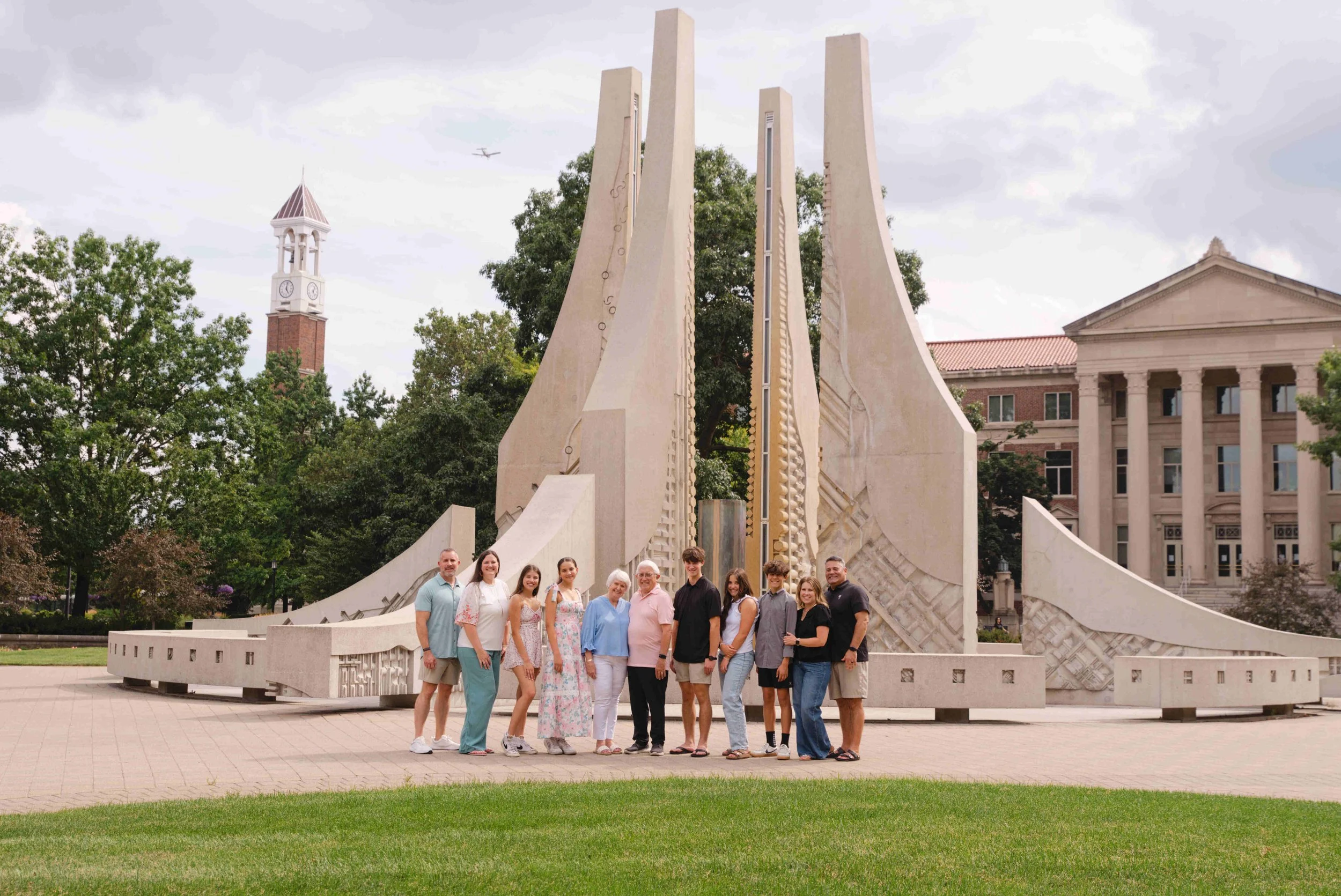 3 generations of family standing in front of the engineering fountain on Purdue University's campus.  The Bell Tower and Hovde hall in the background.  Photo by Heather Corbin Photography
