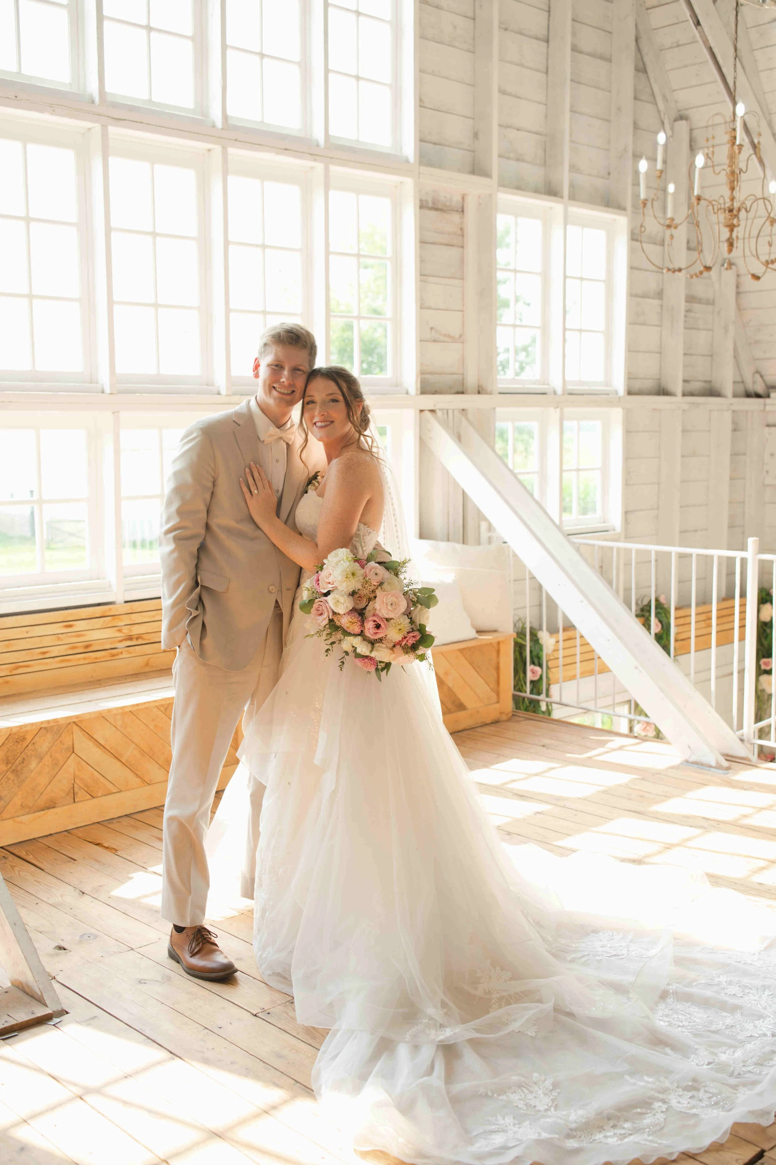 Bride and groom posing in front of the large windows in the loft upstairs of the Blossom Barn, Mulberry Indiana