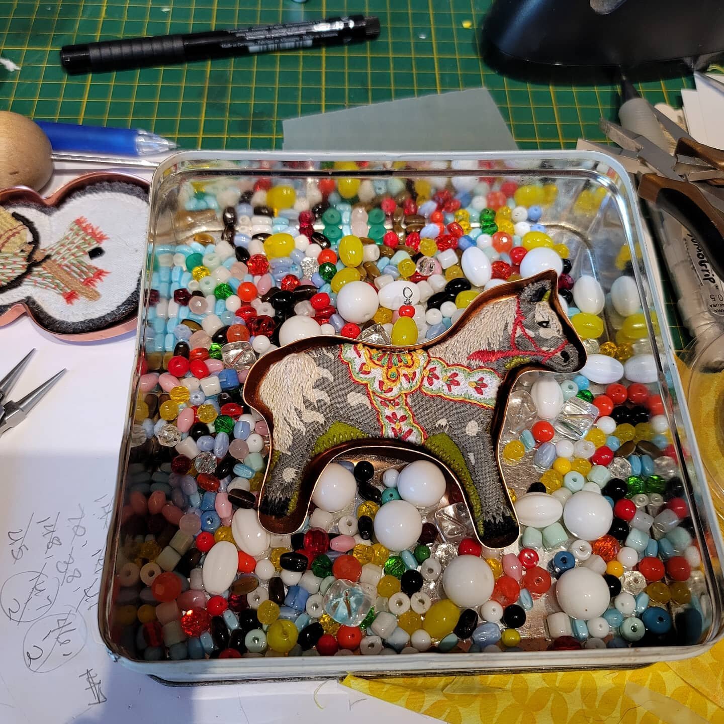 Putting some beads and loops on some finished #vintagecookiecutters ornaments and loved how cool the #dalahorse looked in my tin of 1950 glass Mardi Gras beads. 
Last time I was in Santa Fe the bead shop off the plaza wasn't there so hopefully it jus