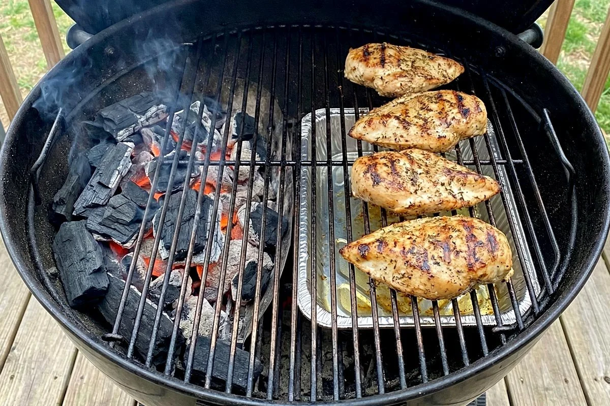 Chicken on a kettle grill with heat zones.