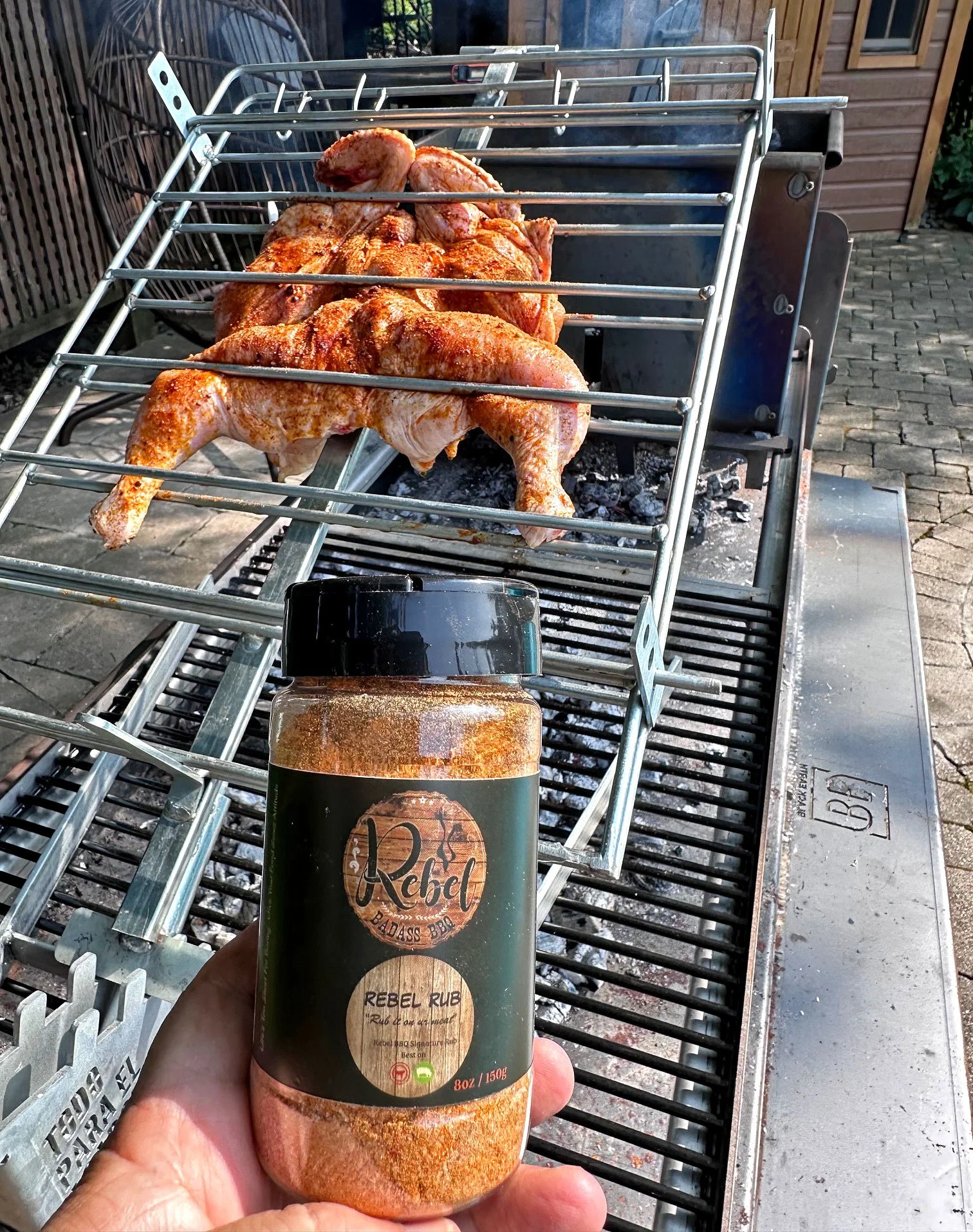 Rebel Badass rub on spatchcock chicken, on a Black Earth Grills Gaucho Grill.