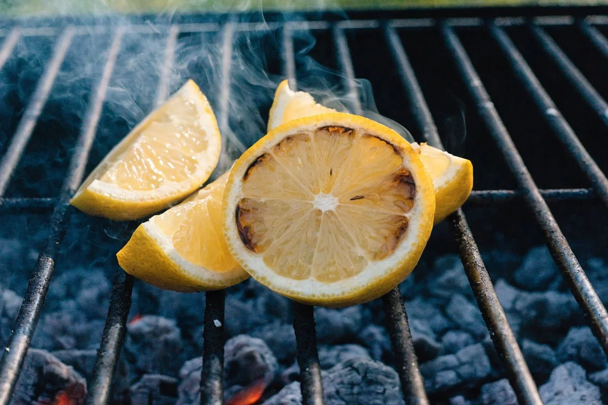 cut lemons on a charcoal grill.