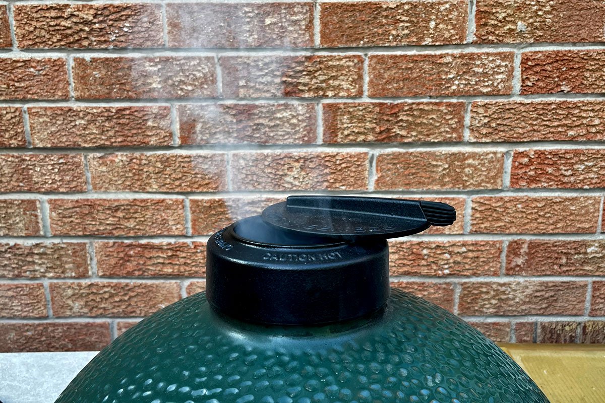 Smoke rising from a Big Green Egg.