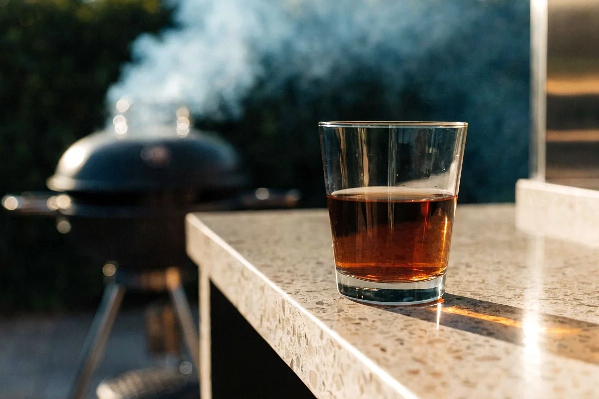 Dark rum in a glass, outdoor kitchen.