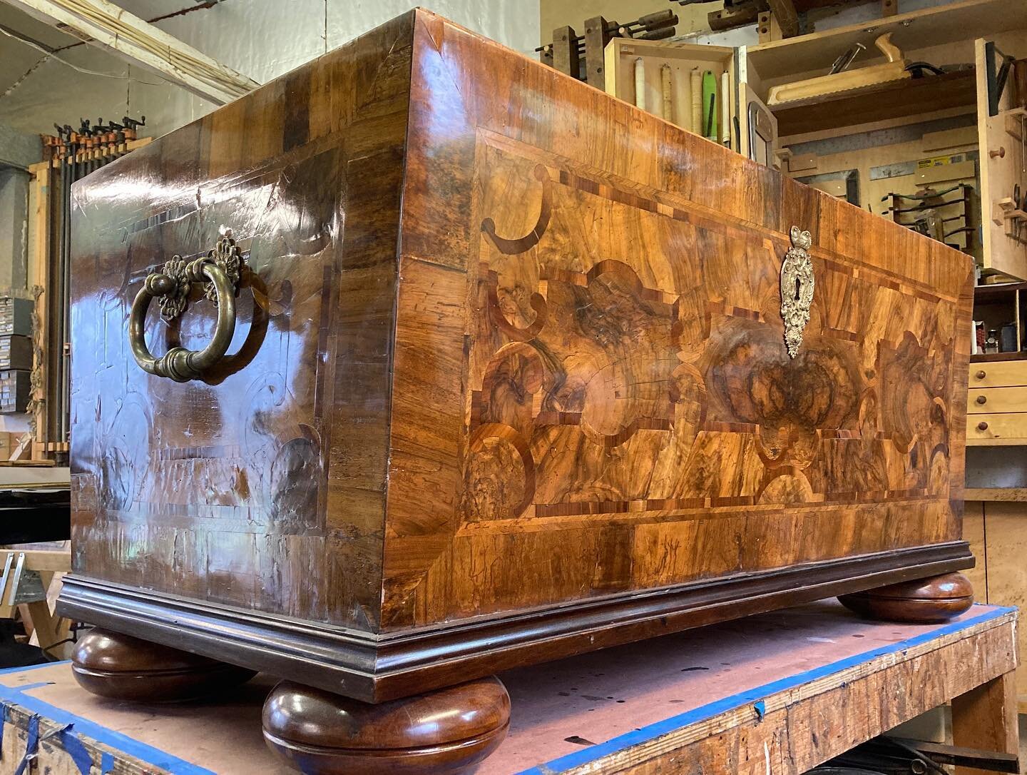 Sometimes you need to find creative solutions to problems such as regluing the lifting veneer on this Biedermeier trunk that&rsquo;s too far in to be reached by even the deepest clamp.  Wedging boards to the rafters in the ceiling gets around that pr