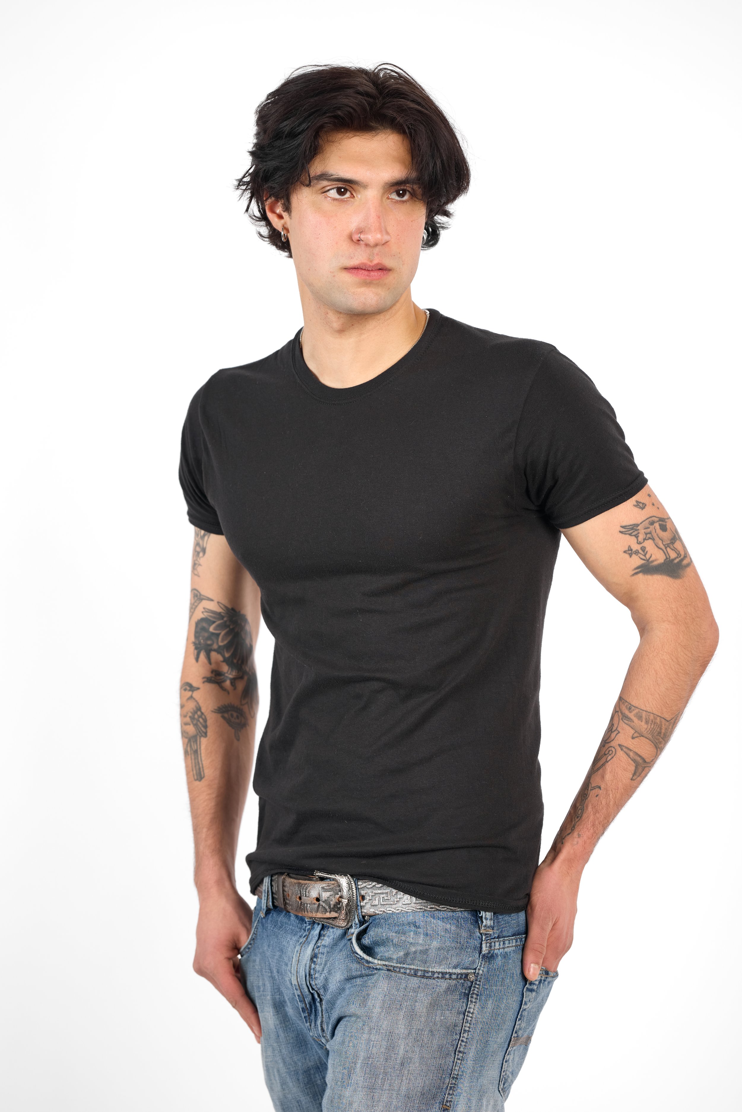 Chicago Modelling Digital of a young man with dark, wavy hair, wearing a black t-shirt and jeans, standing against a plain white background.