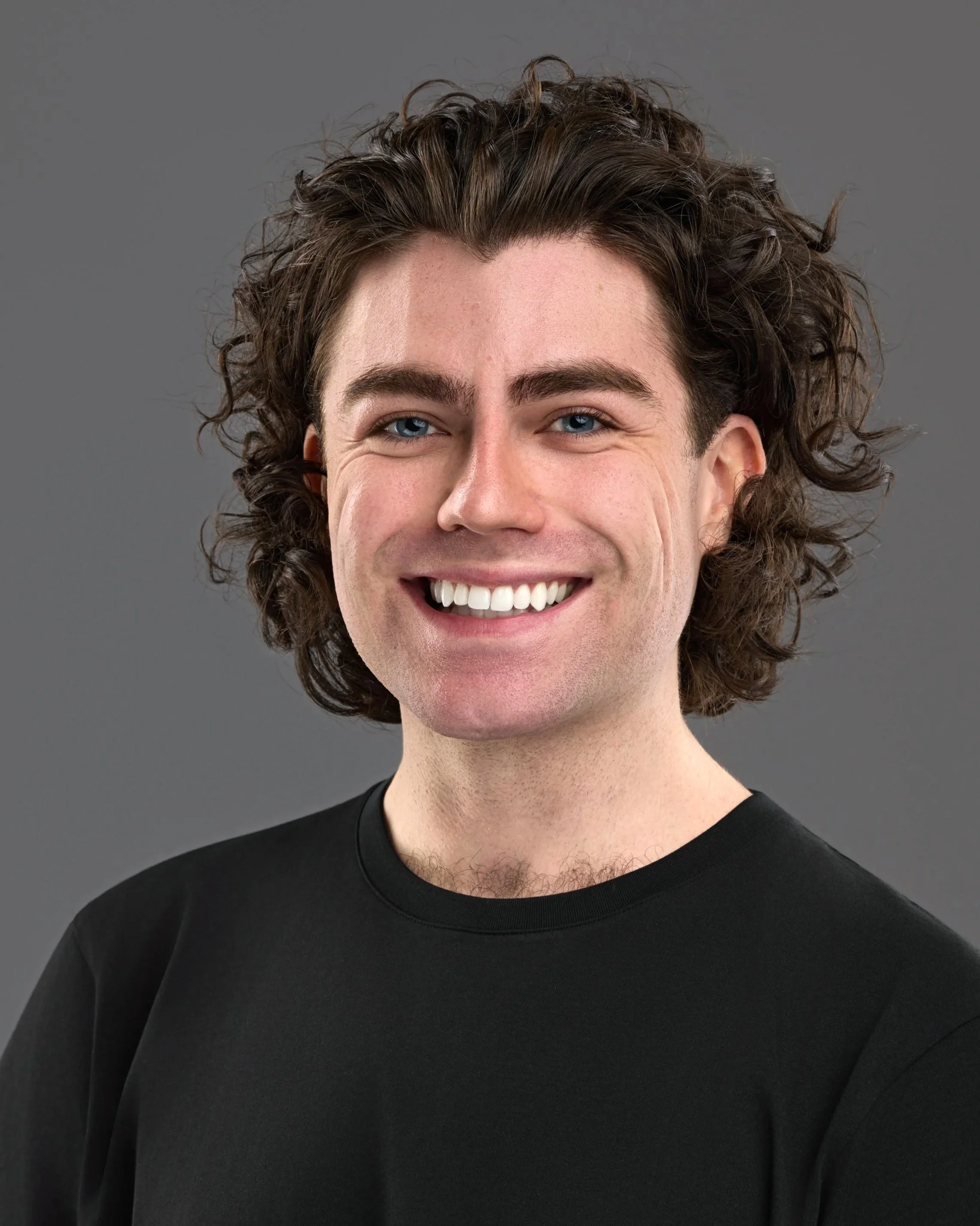 Chicago professional headshot portrait of a young actress with curly brown hair and blue eyes, smiling, wearing a black shirt against a gray background.