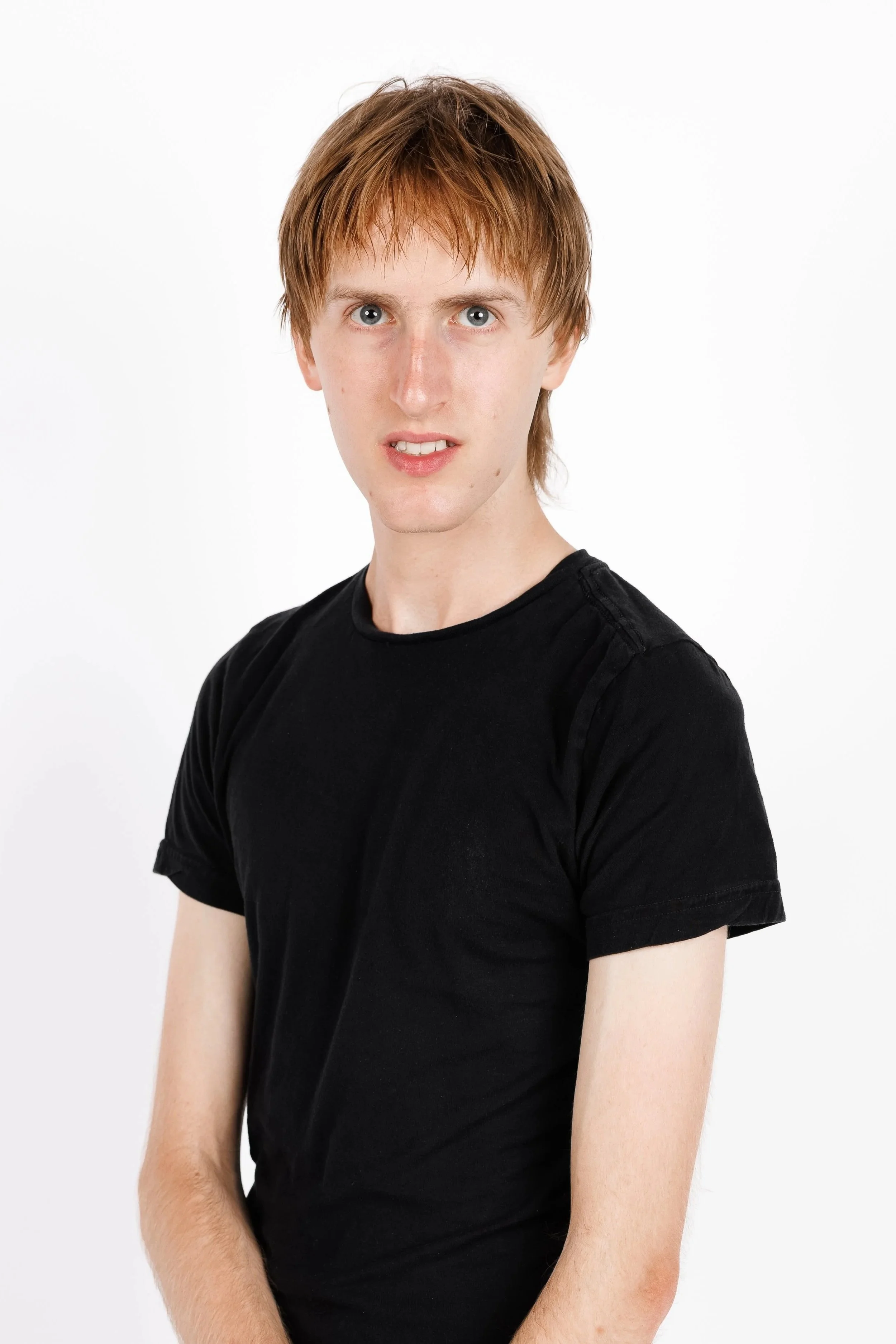 Chicago Modelling Digital of a young man with red hair wearing a black t-shirt standing against a white background.