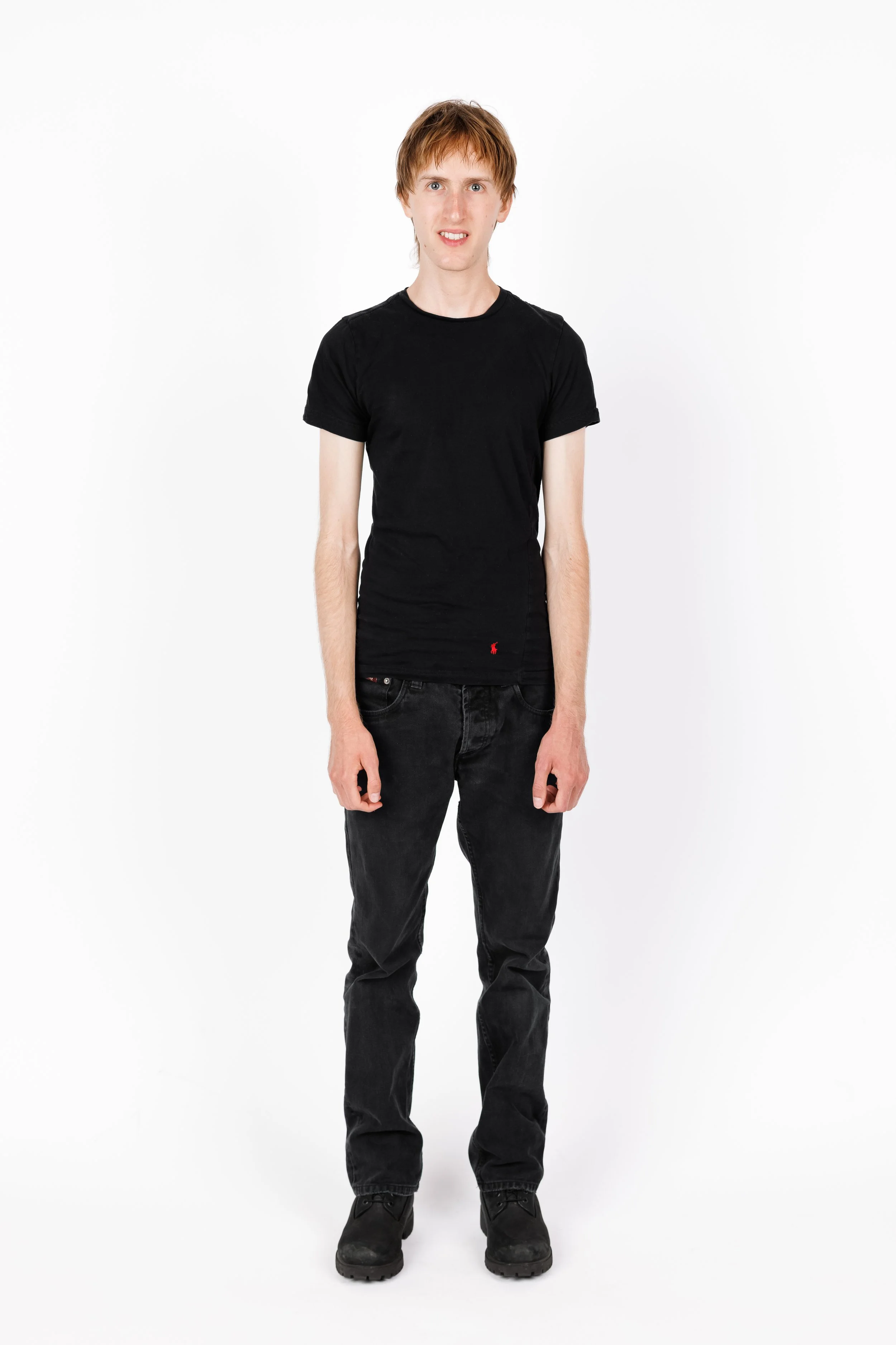 Chicago Modelling Digital of a young man with light skin, red hair, wearing a black t-shirt, black jeans, and black shoes standing against a white background.
