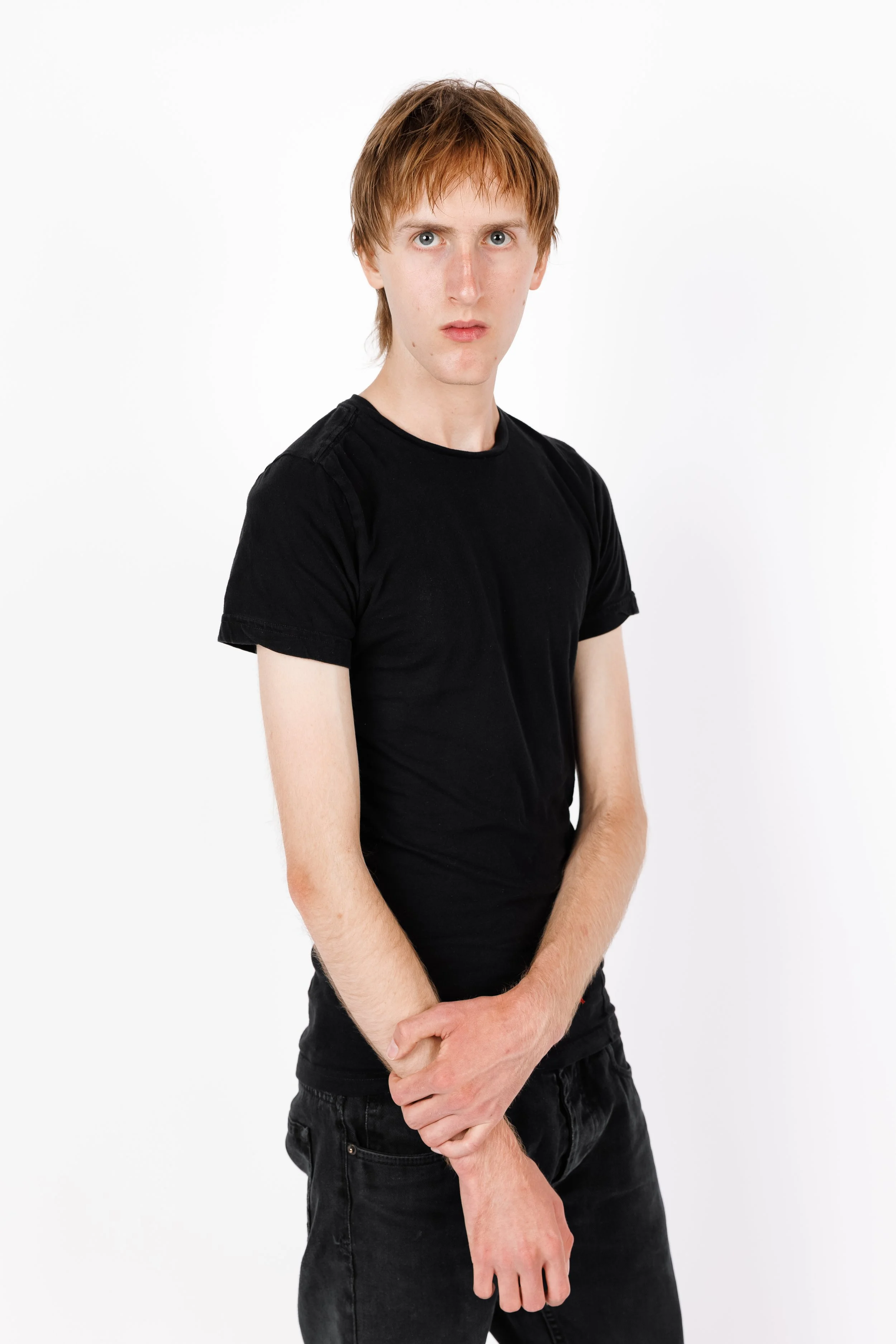 Chicago Modelling Digital of a young man with ginger hair and fair skin wearing a black t-shirt and black jeans, standing against a plain white background.