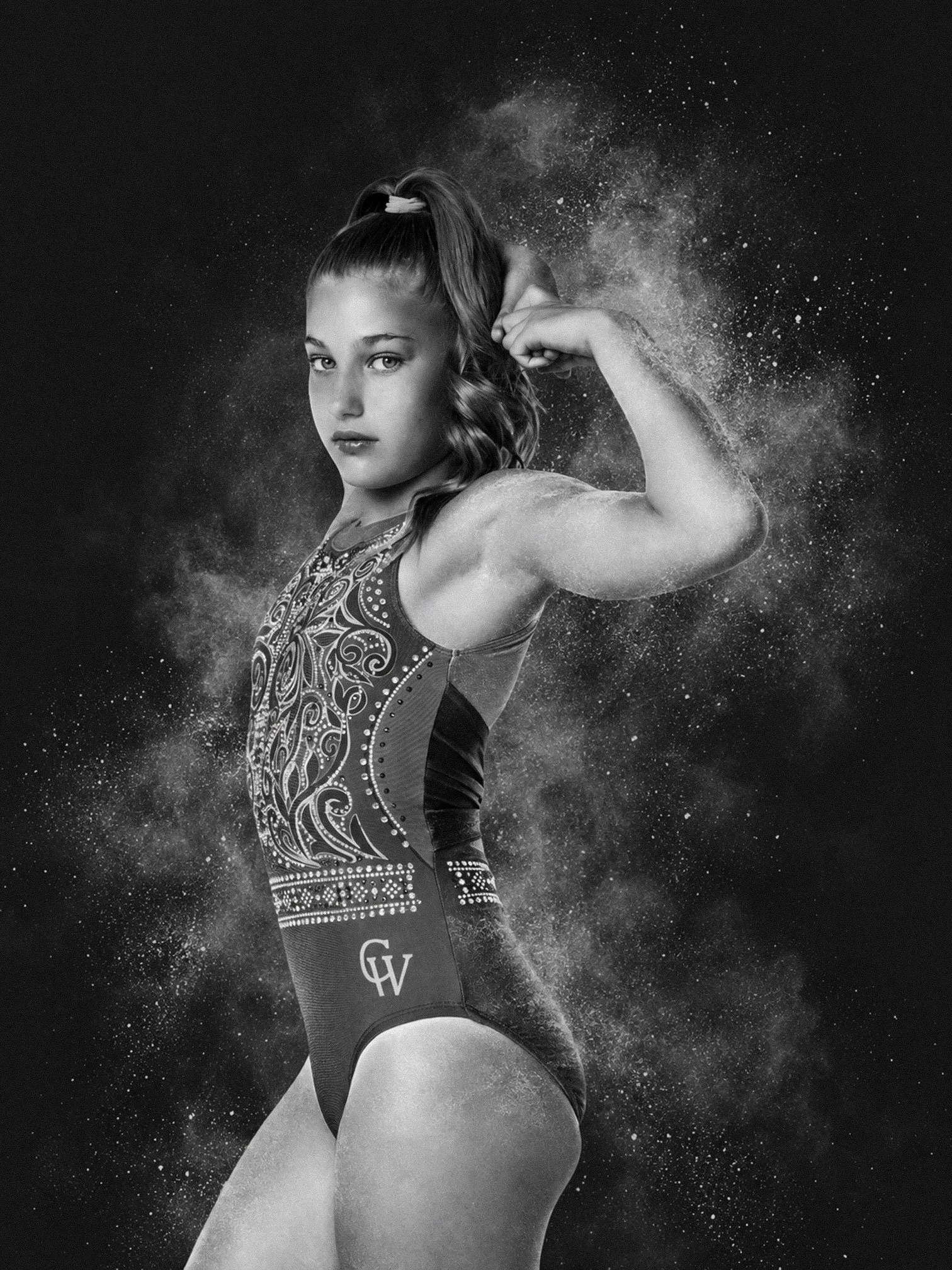 black and white photo of a young gymnast with chalk around them