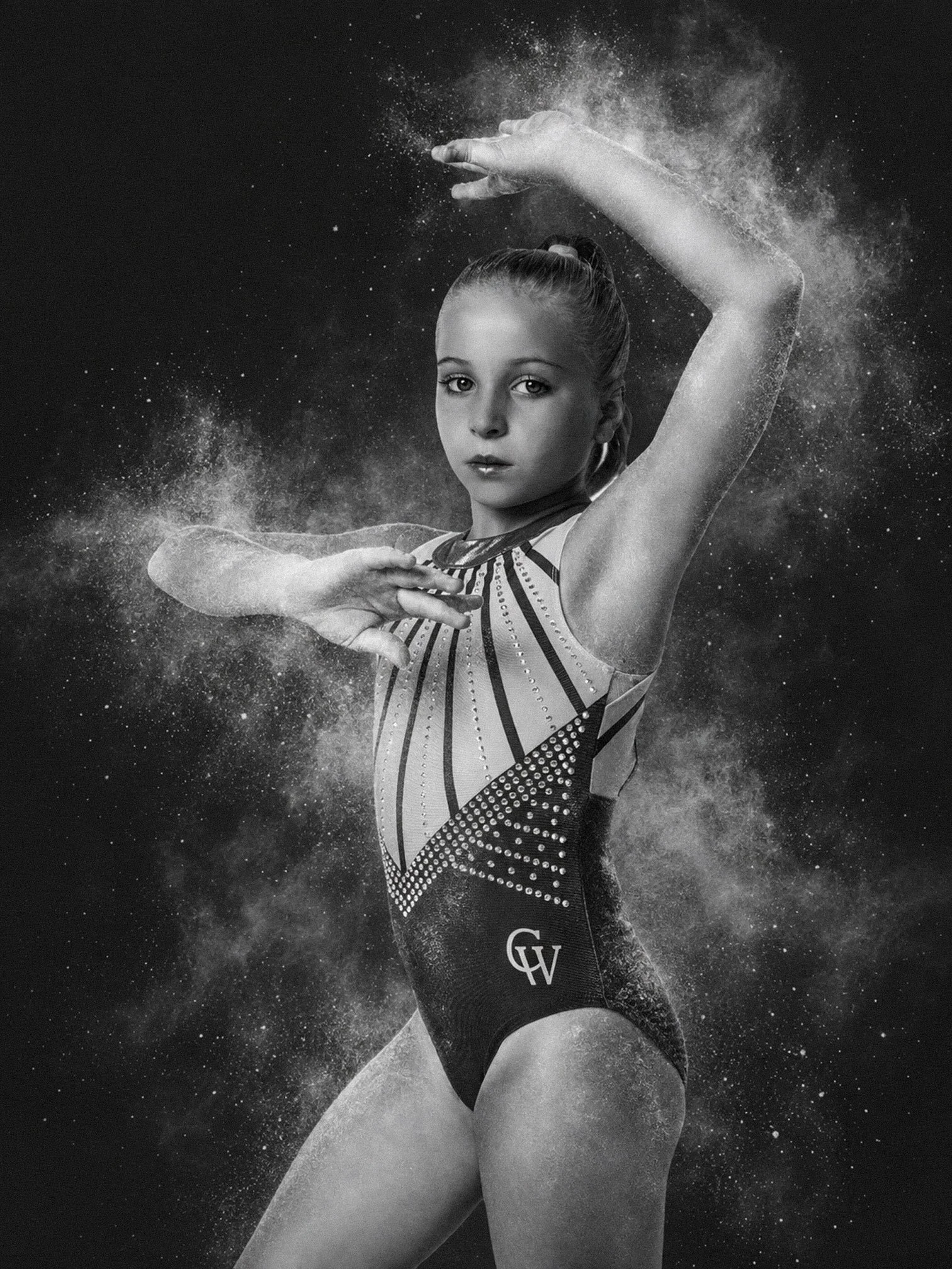 black and white photo of a young gymnast with chalk around them