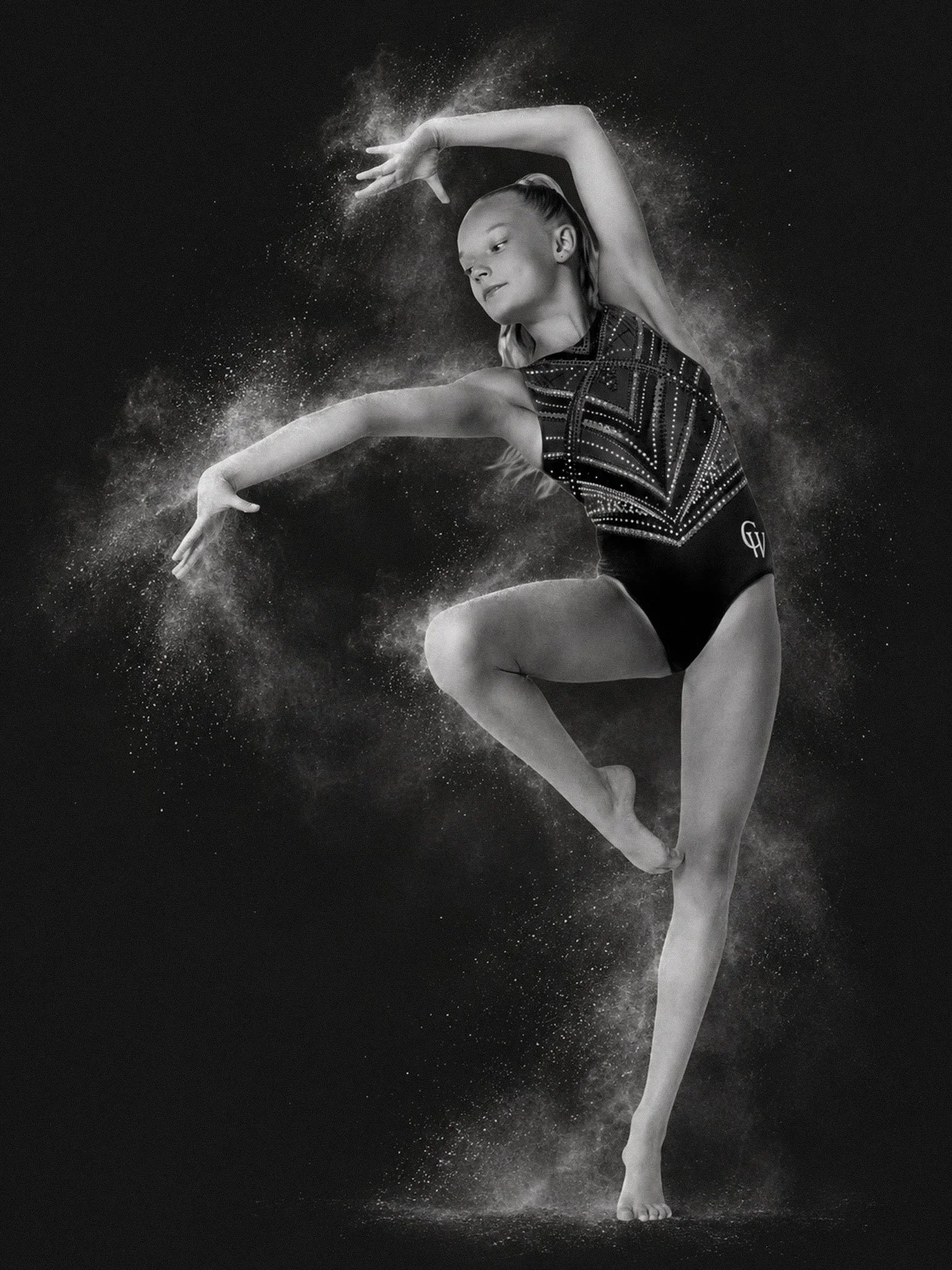 black and white photo of a young gymnast with chalk around them