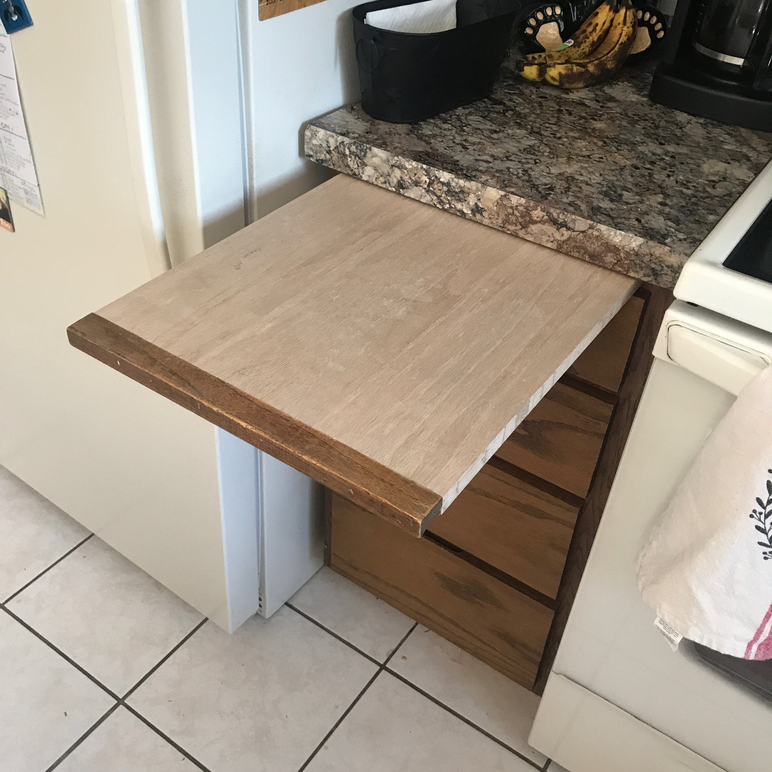 Integrated cabinet slide out cutting board in oak.