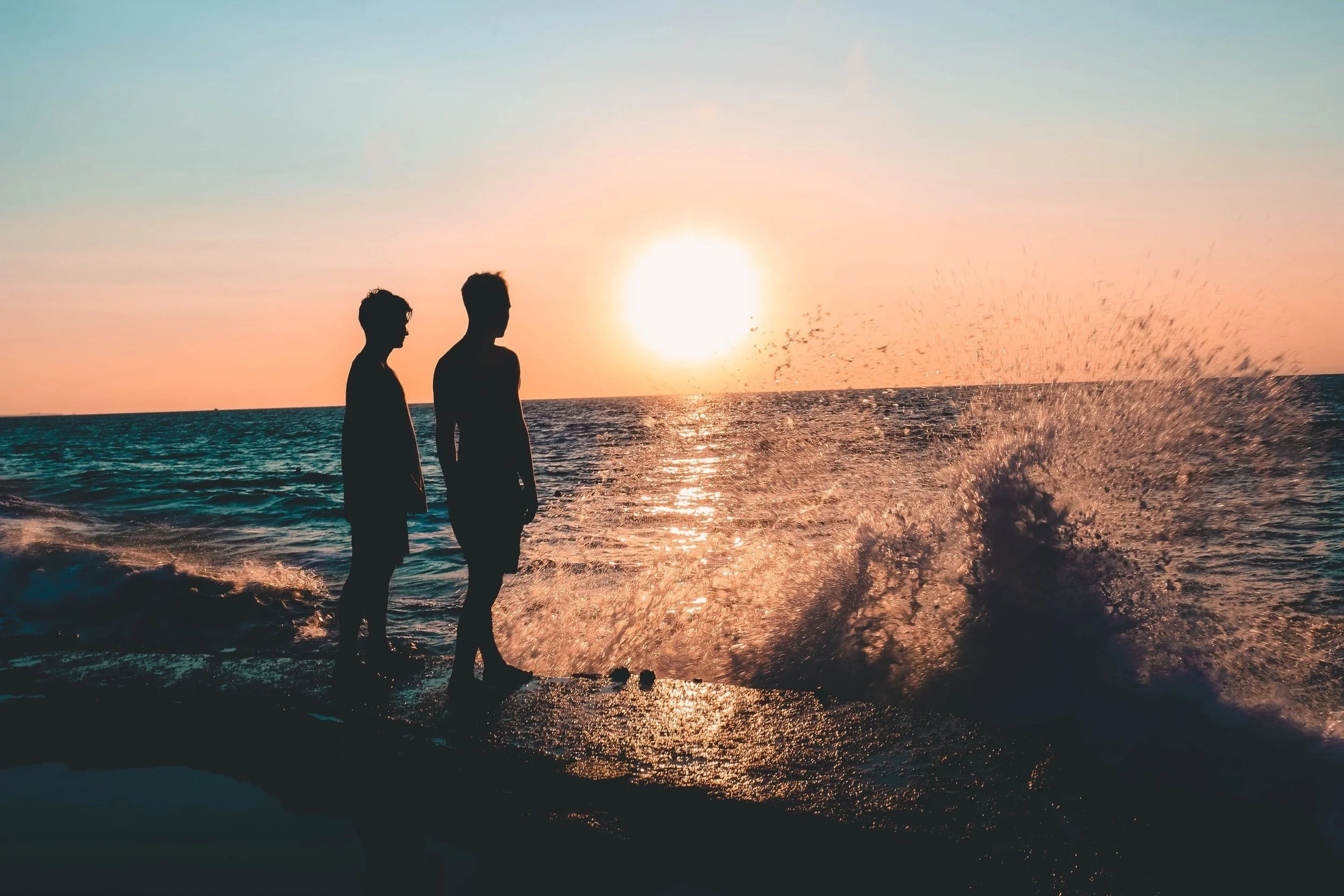2 people silhouetted looking out to sea