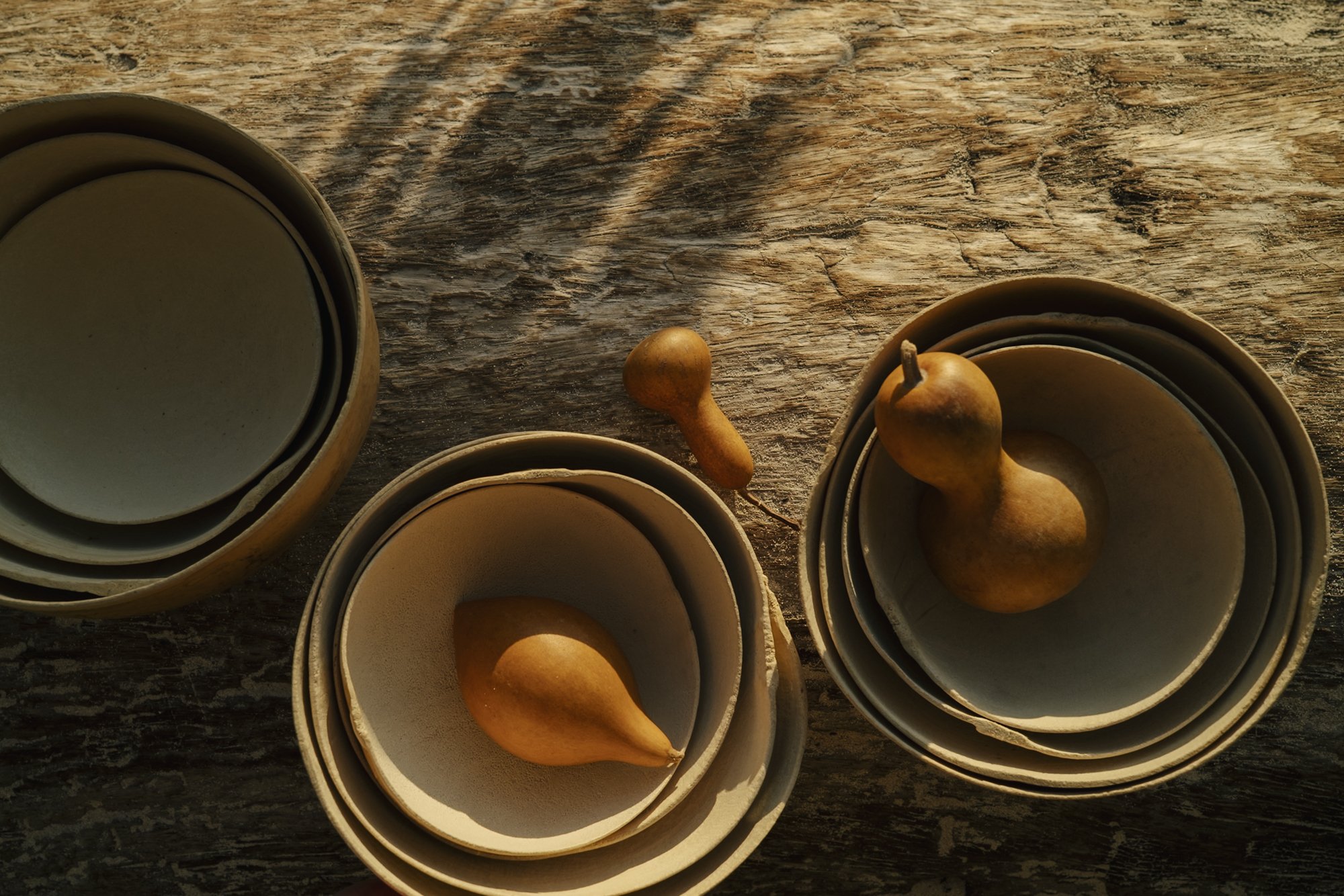 Boules en bois avec des poires en céramique posées dessus, sur une surface en bois.