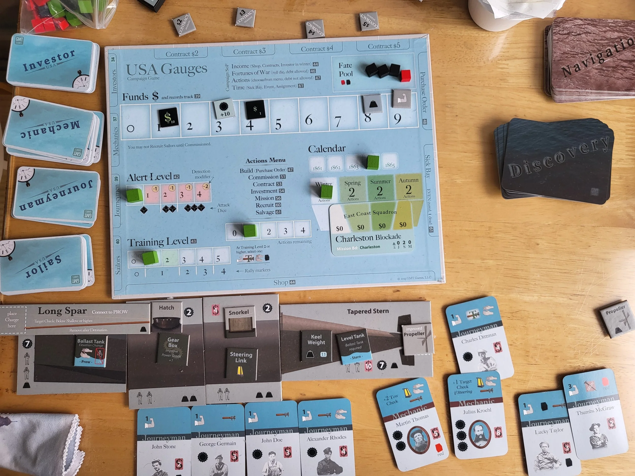 Photo of the campaign board for the USA campaign, with a built fish boat and crew cards scattered across my table.