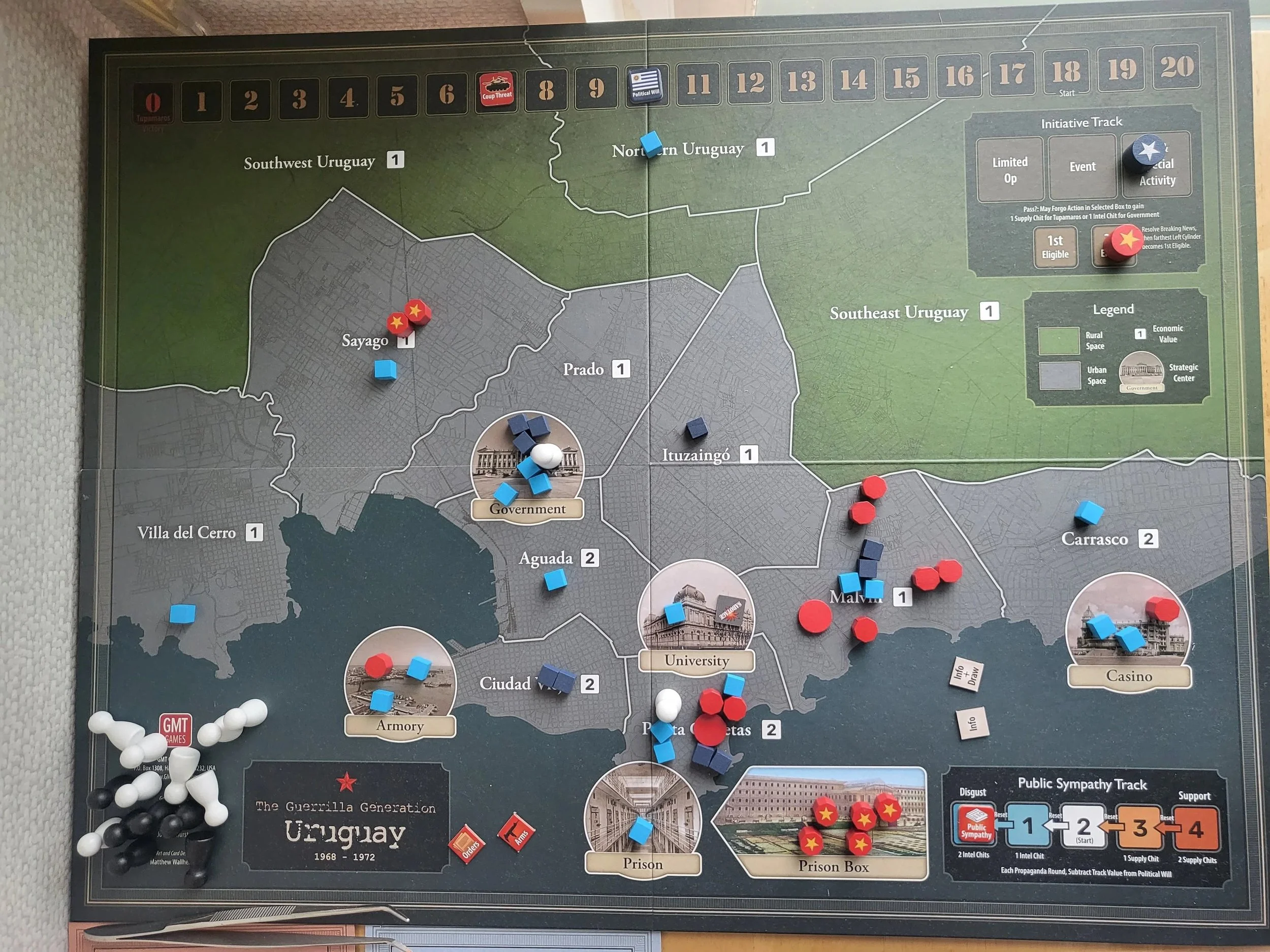 A photo of the board for Uruguay in the middle of a game with blue and red pieces spread across its spaces