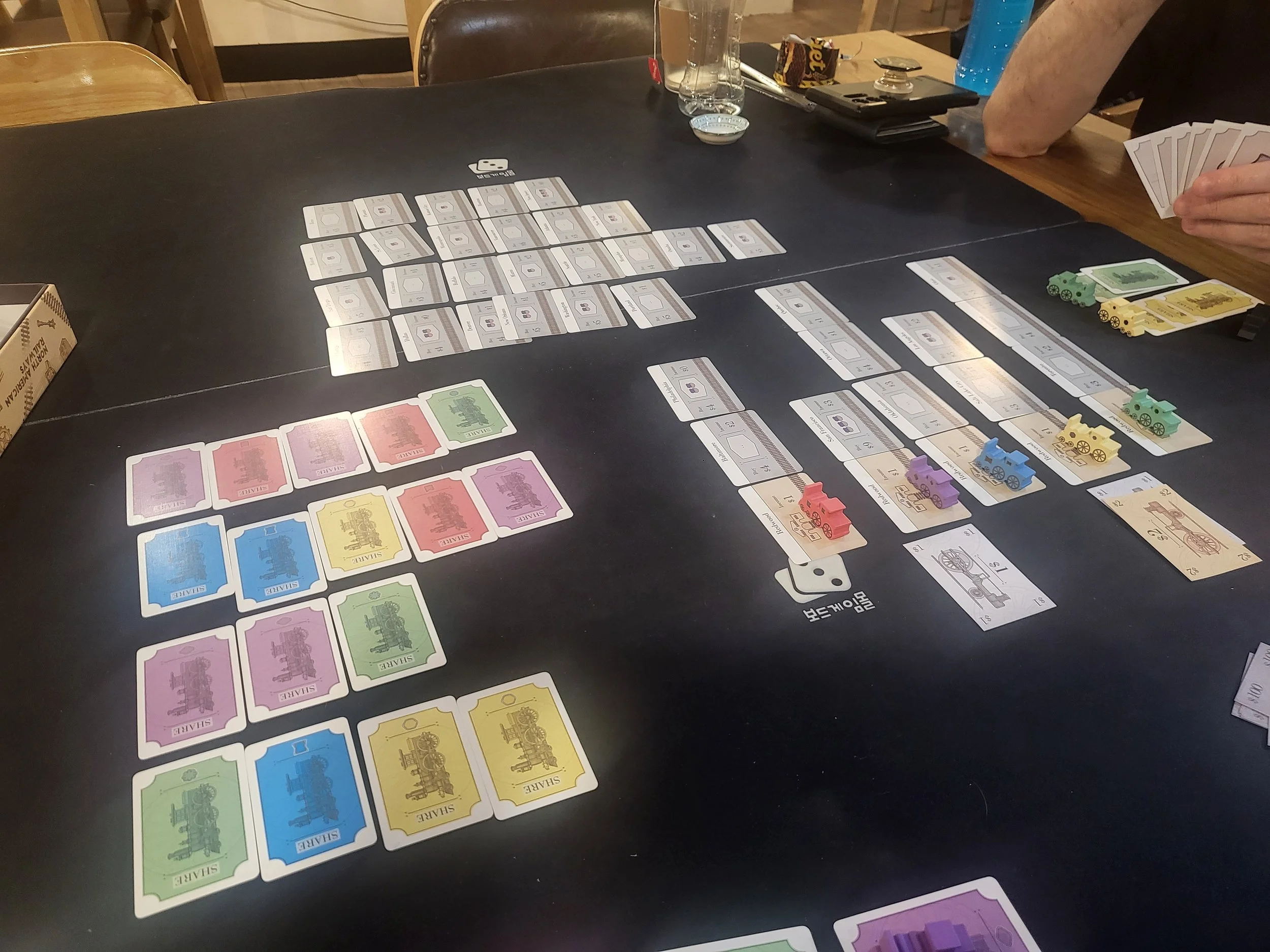 Photo of North American Railways in play - there are four displays of cards (stocks, routes, and the current companies)