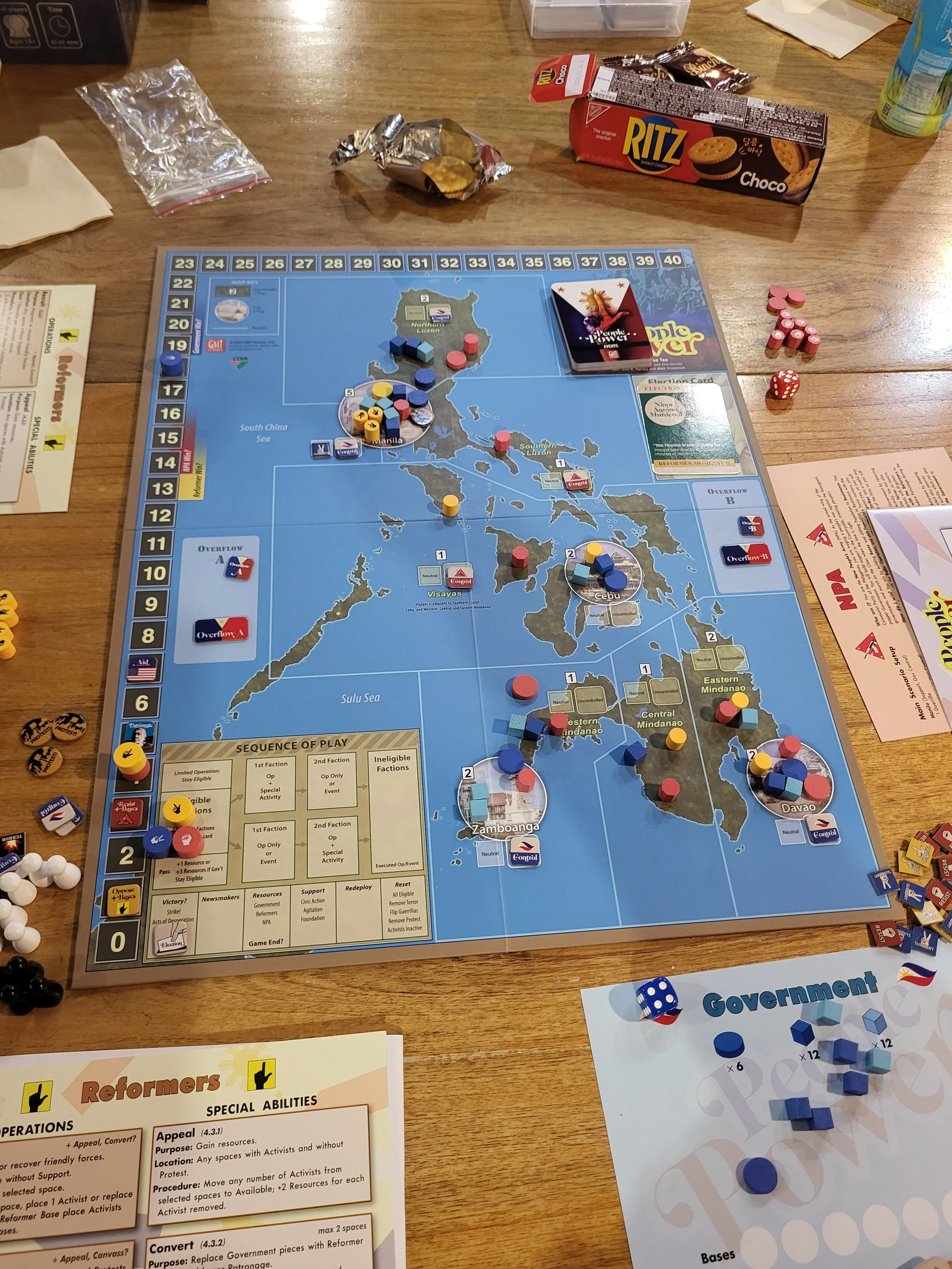 Photo of the initial set up for People Power. Looking from the bottom of the board up, you can see my government play mat in the bottom corner.