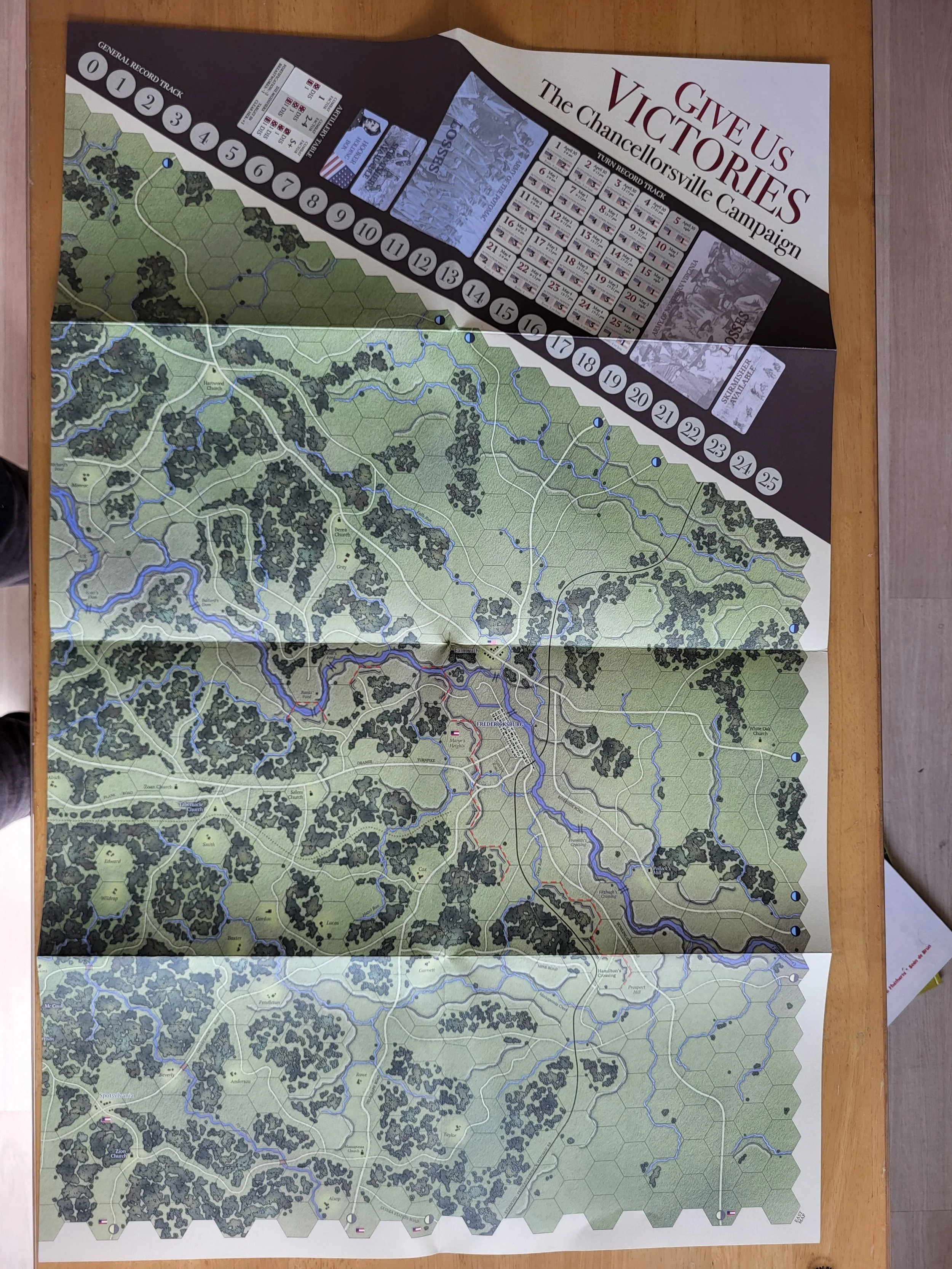 One map sheet from Give Us Victories, showing the easter half of the battle as well as the turn track and other displays, laid out on my table. it takes up basically the whole table on its own.