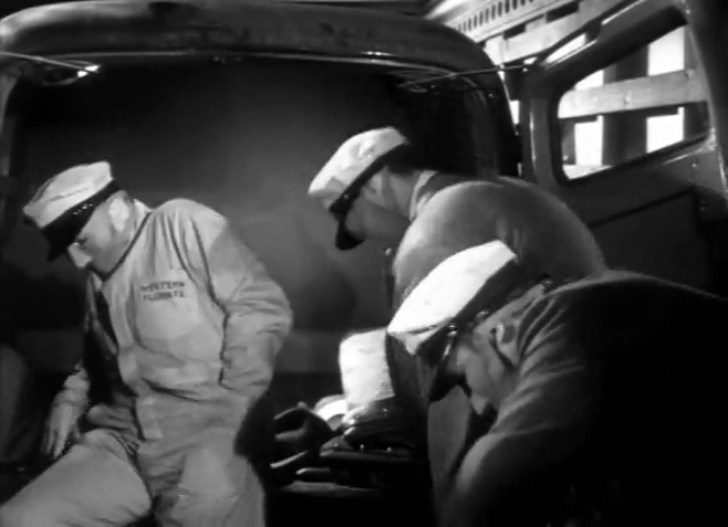 Three men in the back of the truck. They are wearing work coveralls and delivery driver hats, and have blank masks covering their noses and mouths that give them a weird clay model aesthetic.