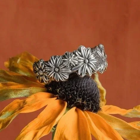 Black-eyed Susan ring in sterling silver sitting on top of a black-eyed Susan dried flower.
