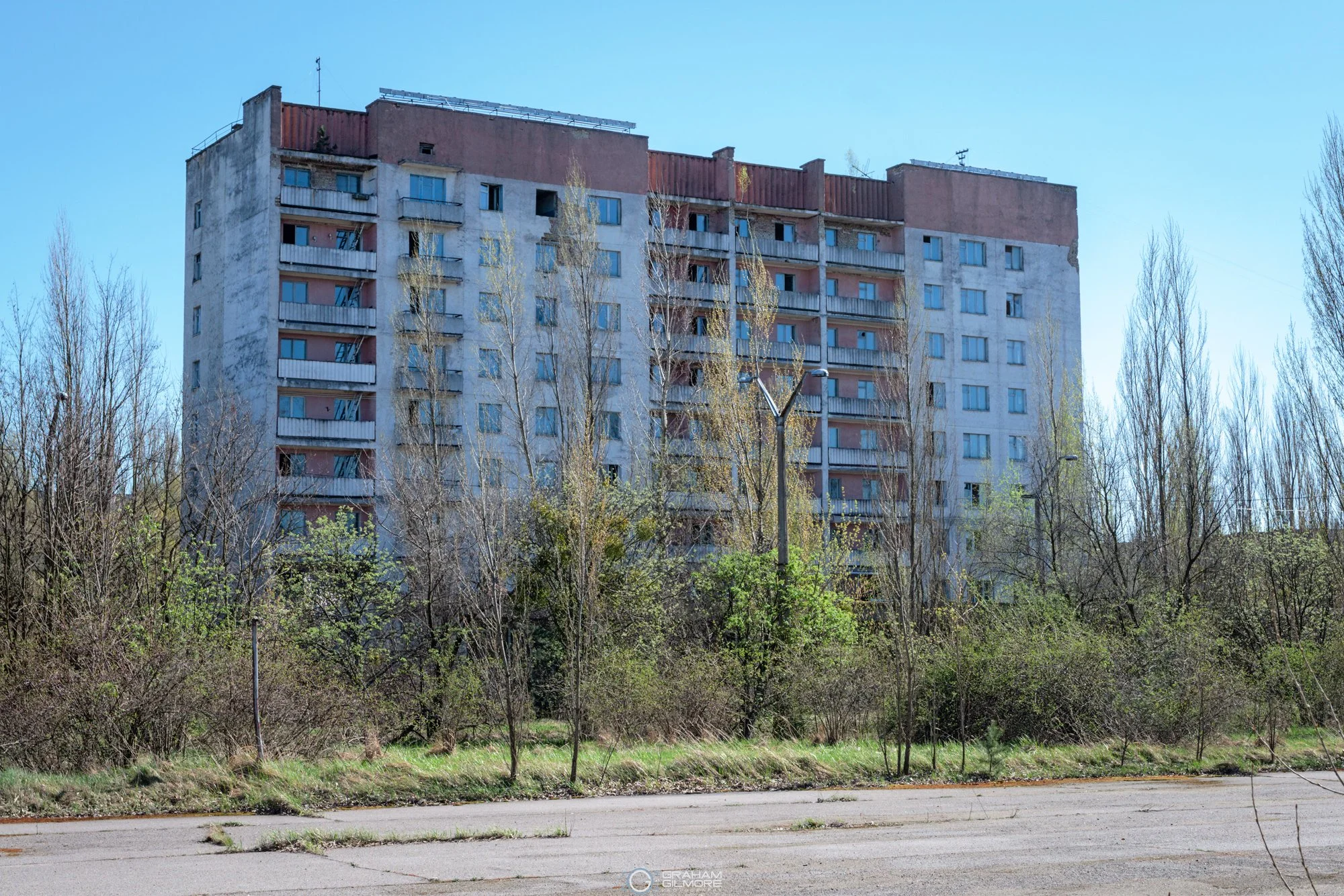 abandoned apartment building in Pripyat surrounded by overgrown trees Ukraine