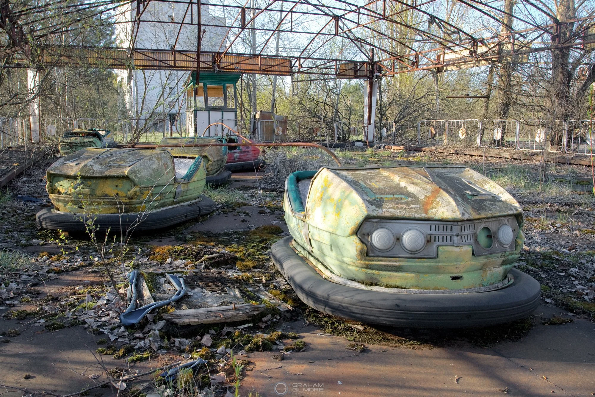 abandoned bumper cars in Pripyat amusement park covered in rust and radioactive moss